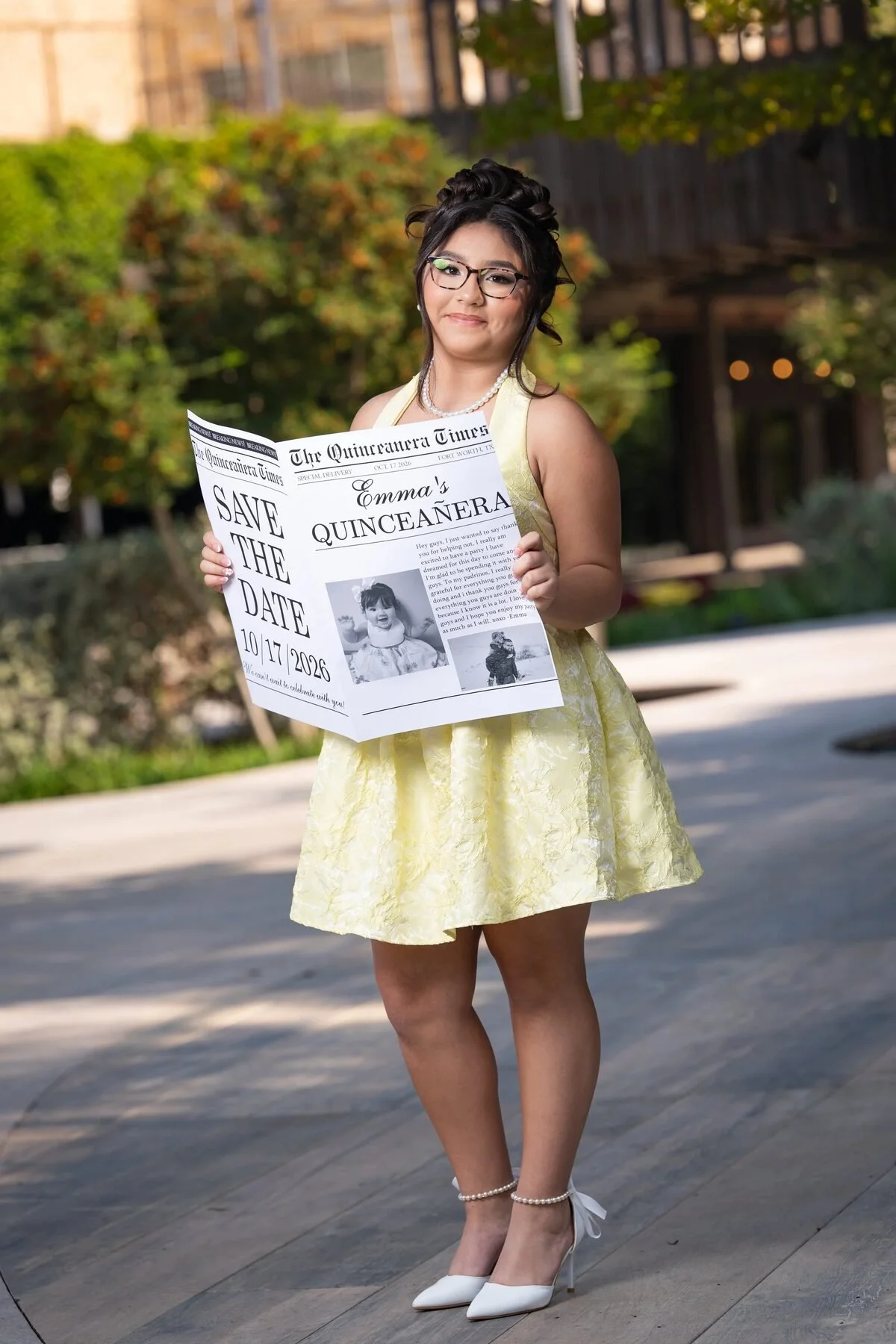 Quinceañera in a yellow dress holding a Save the Date newspaper prop in Texas