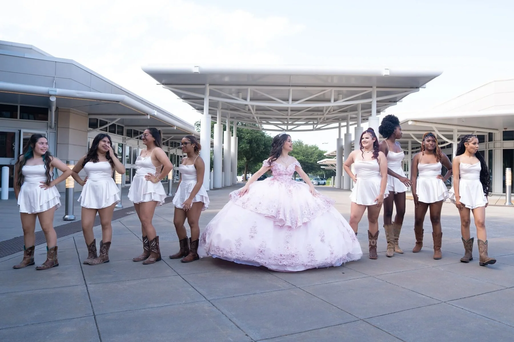 Quinceanera and her court in cowboy boots gather outside a DFW event venue.