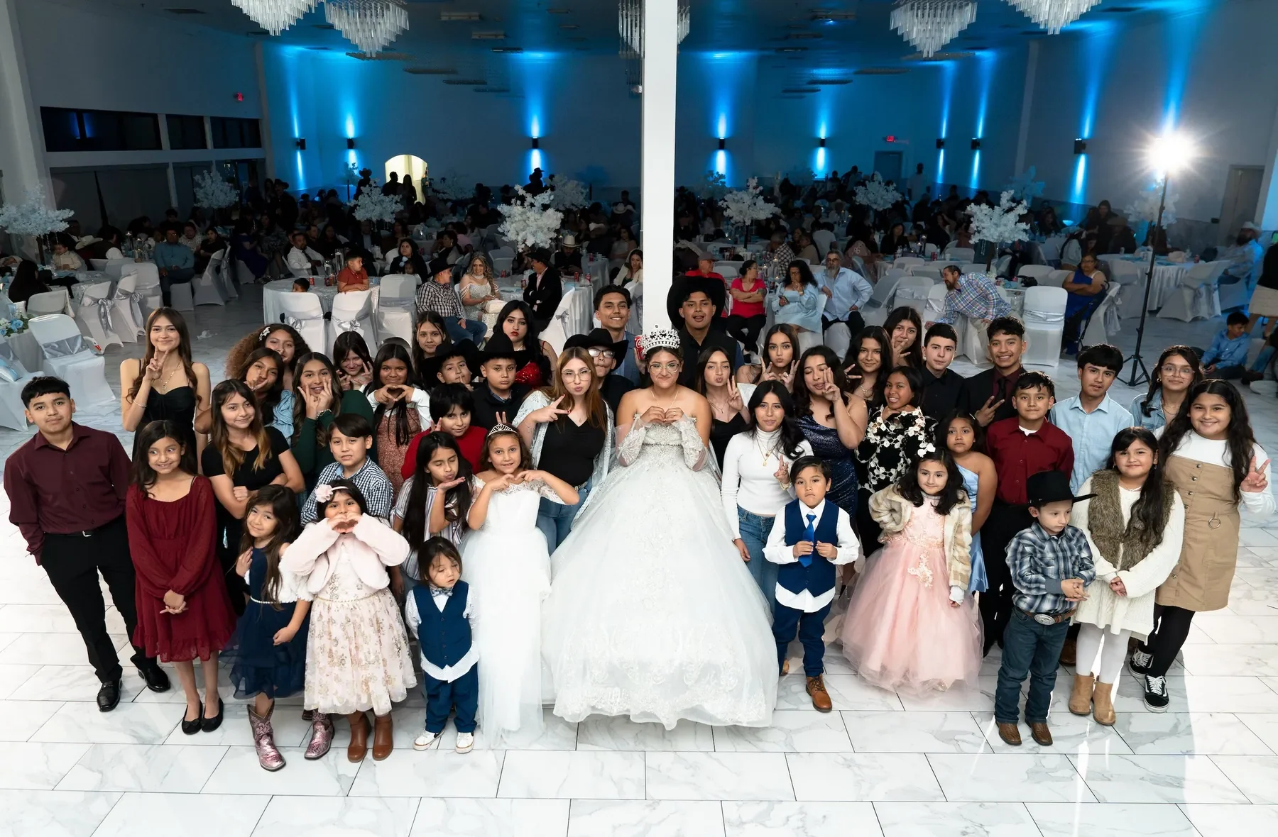 Quinceañera surrounded by friends and family for a group portrait at her Fort Worth, Texas reception.