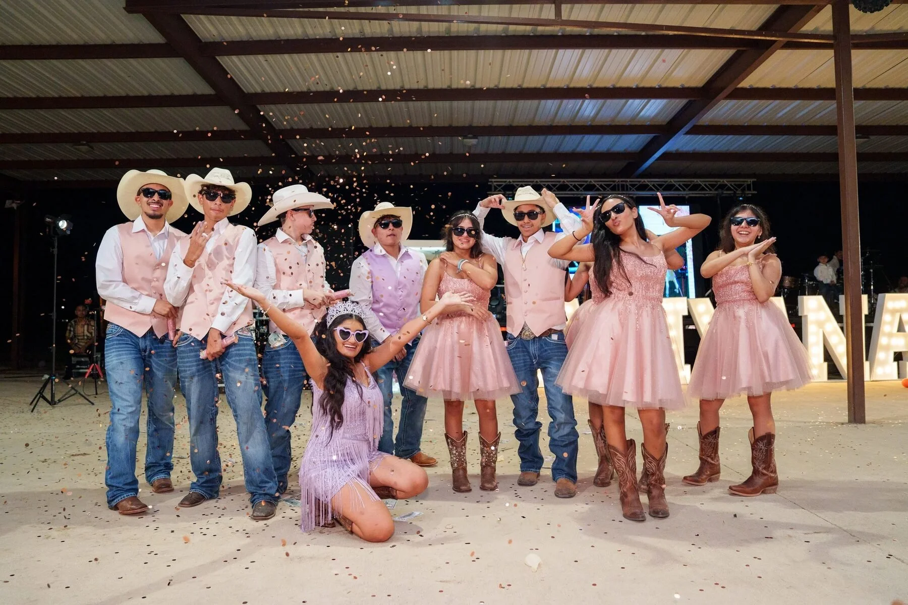 Quinceañera and her charro-themed court celebrating with confetti at a Dallas reception