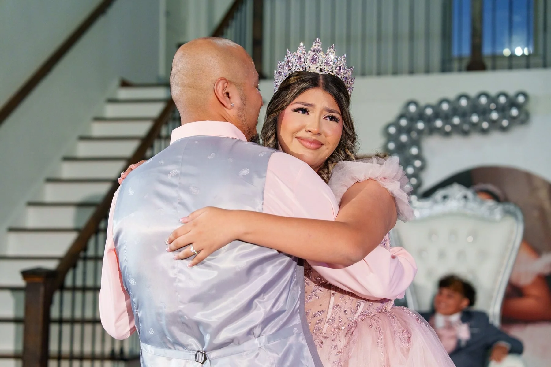 Padre e hija comparten un vals emotivo, la hija con vestido rosa, en una quinceañera de Fort Worth