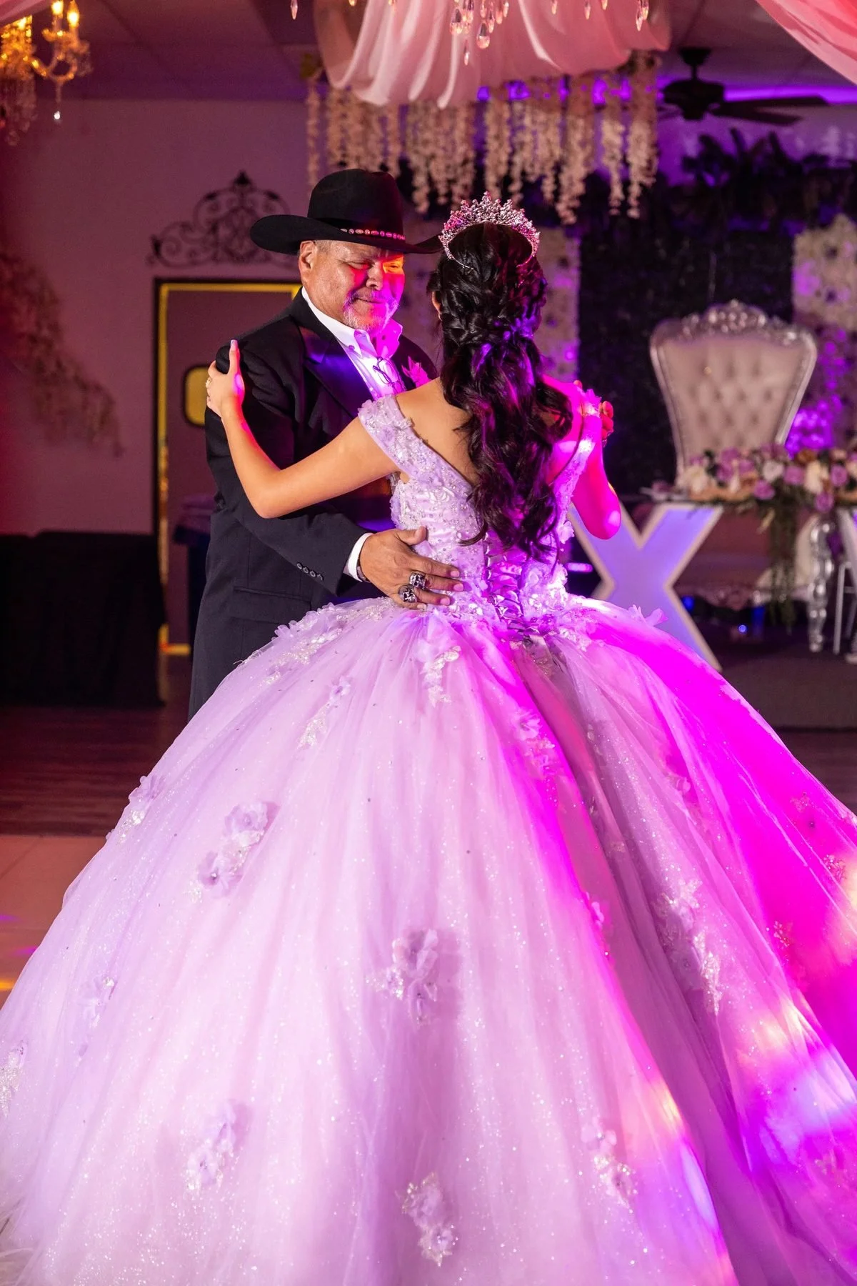 Father in a cowboy hat dancing with his daughter in a blush pink ball gown at her Fort Worth quinceañera.