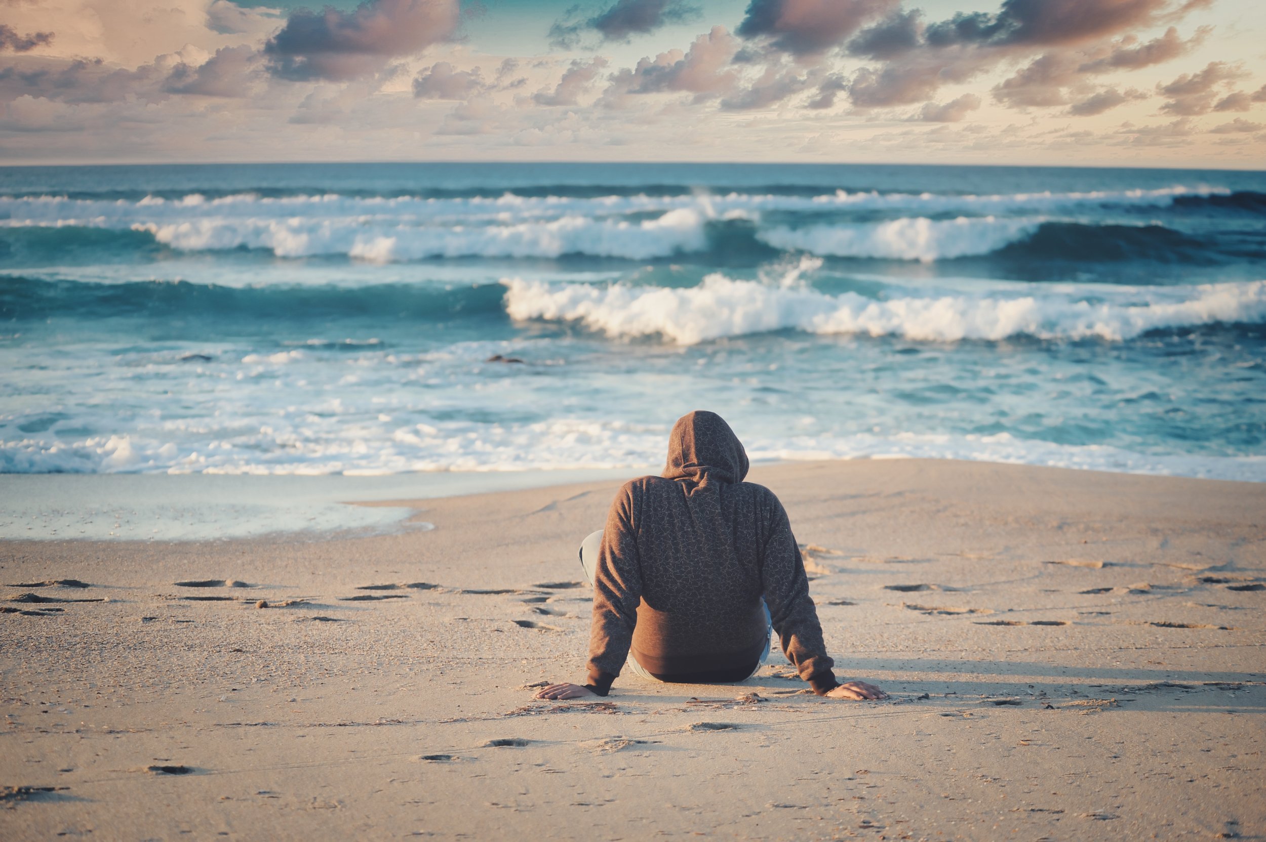 A picture of a man on the beach look at the waves