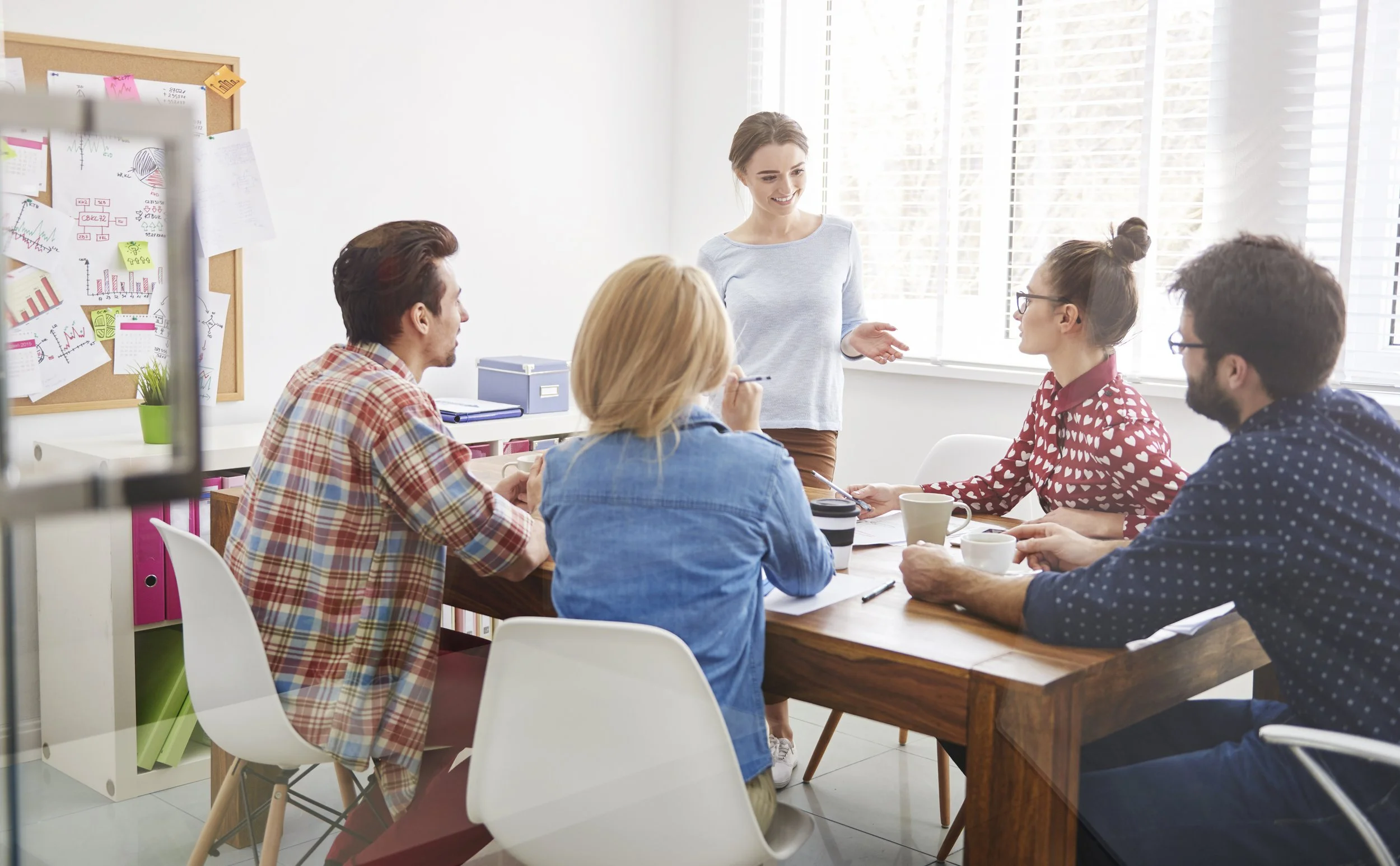 A group of staff sitting at a boardroom table discussing positive ways forward.