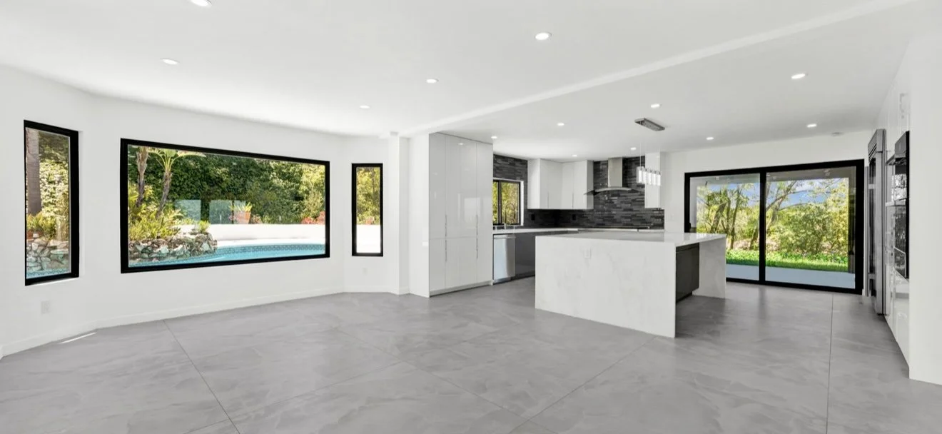 Open-plan kitchen and living space with white cabinets and sliding doors.