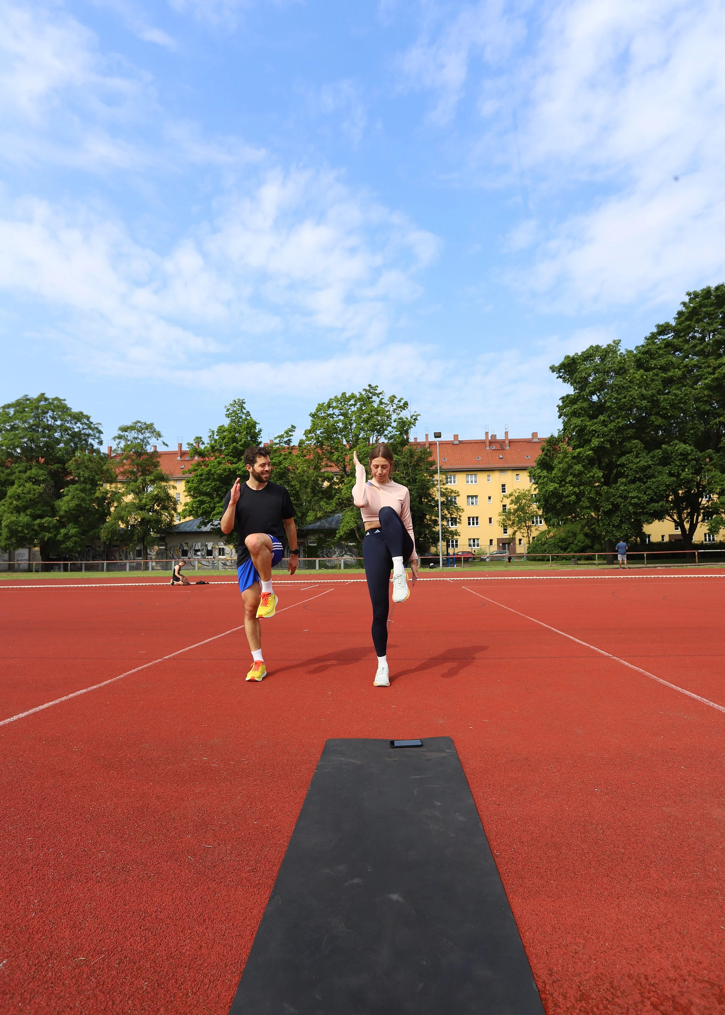 Laufcoach trainiert mit Läuferin auf der Laufbahn – Vorbereitung auf 10 km oder Halbmarathon