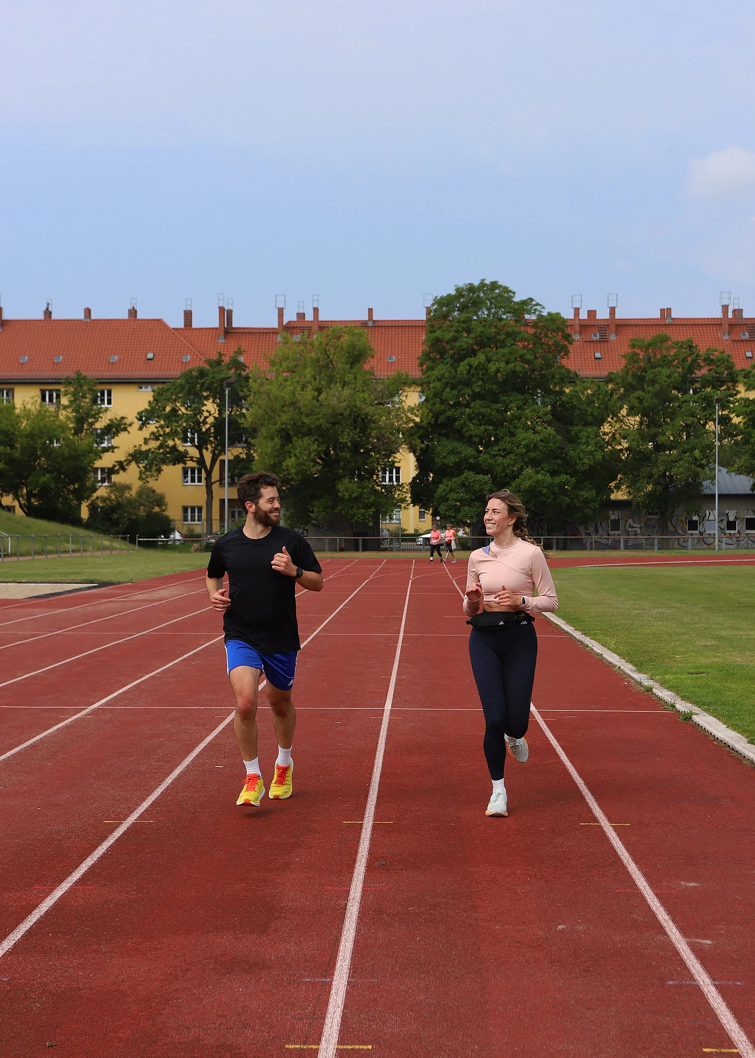Laufcoach trainiert mit Läuferin auf der Laufbahn