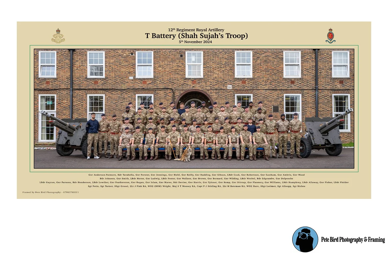 Group photo of soldiers from the 12th Regiment Royal Artillery T Battery (Shah Sujah's Troop), taken in front of a brick building with two artillery cannons on either side, dated November 5, 2024.