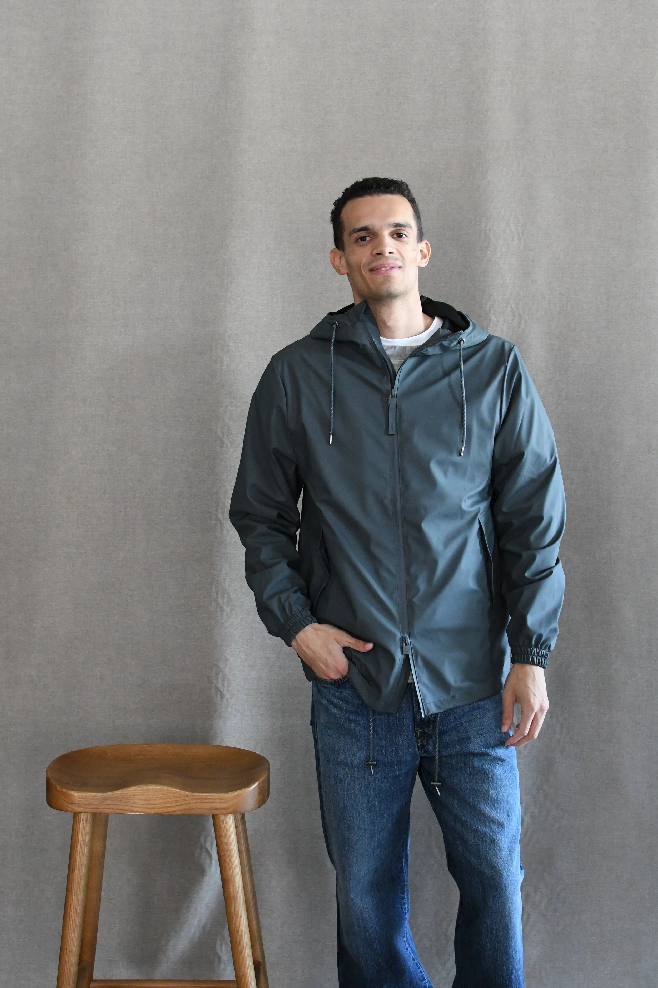 Giubbino Rains Storm Breaker è un impermeabile unisex con un'estetica sportiva raffinata e parti metalliche resistenti agli agenti atmosferici.