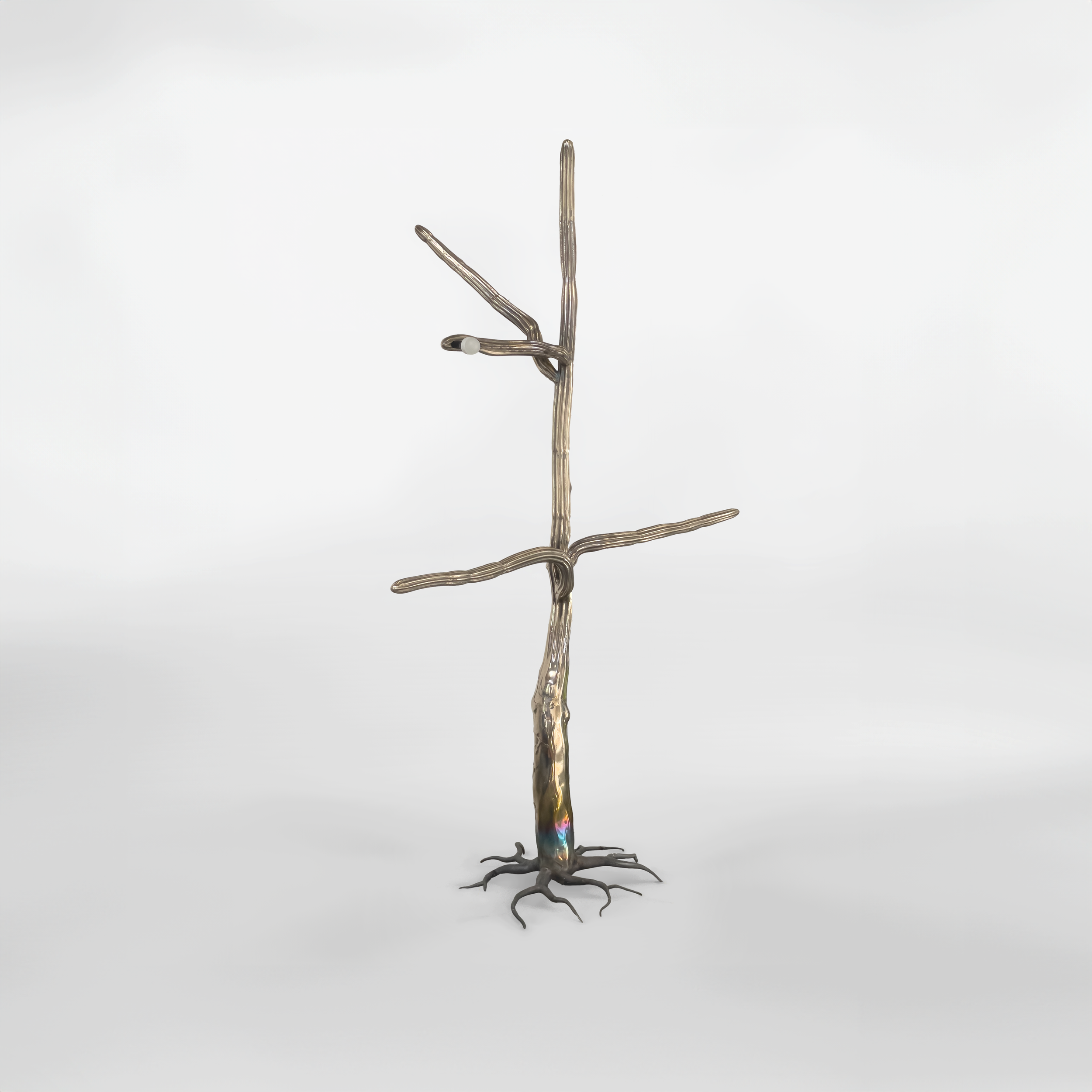 An abstract sculpture resembling a tree with branches, made of metallic and wire-like materials, mounted on a small base against a plain white background.