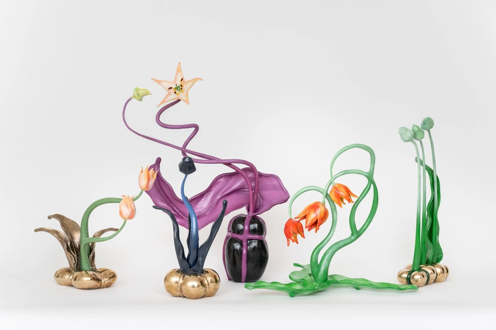 Colorful glass sculpture of various abstract flowers and plants on a white background.
