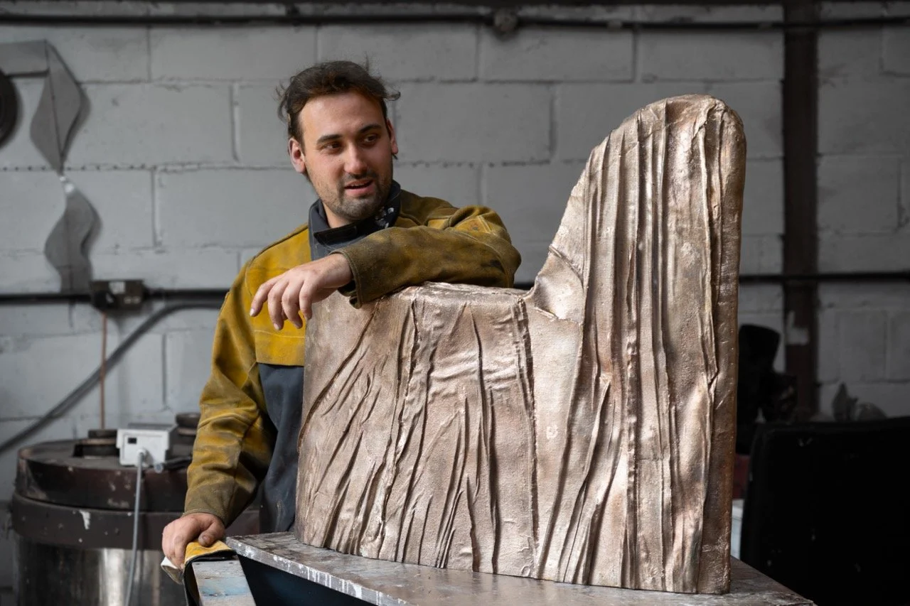 A man working on a sculpture of a mountain in a workshop.