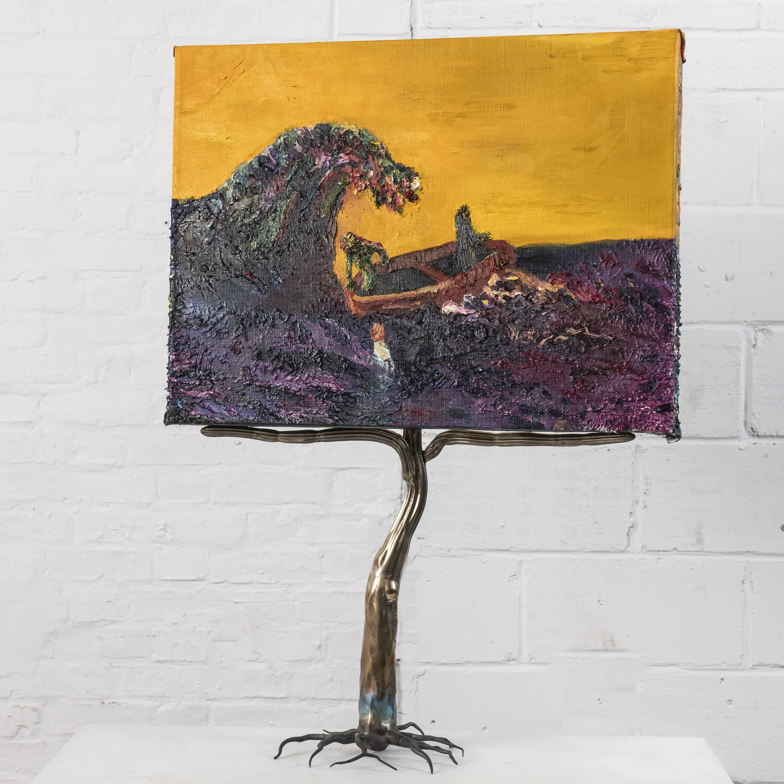 Painted artwork featuring a large wave, a boat, and a figure standing on dark, textured ground, with a bright yellow background, supported by a metallic stand resembling tree roots.