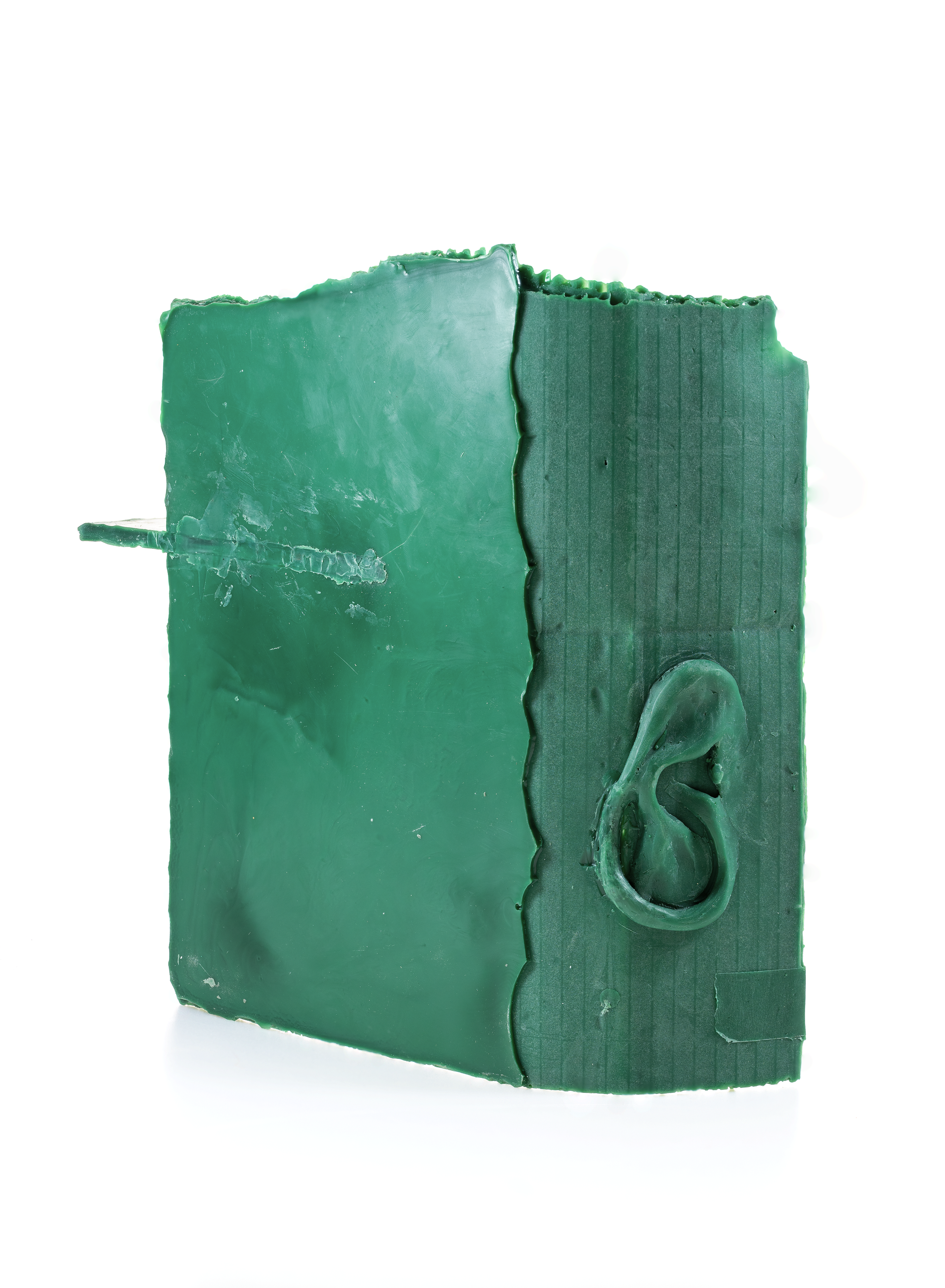 Close-up of a green soap bar with a seahorse design embedded on one side and a textured pattern on the other side.