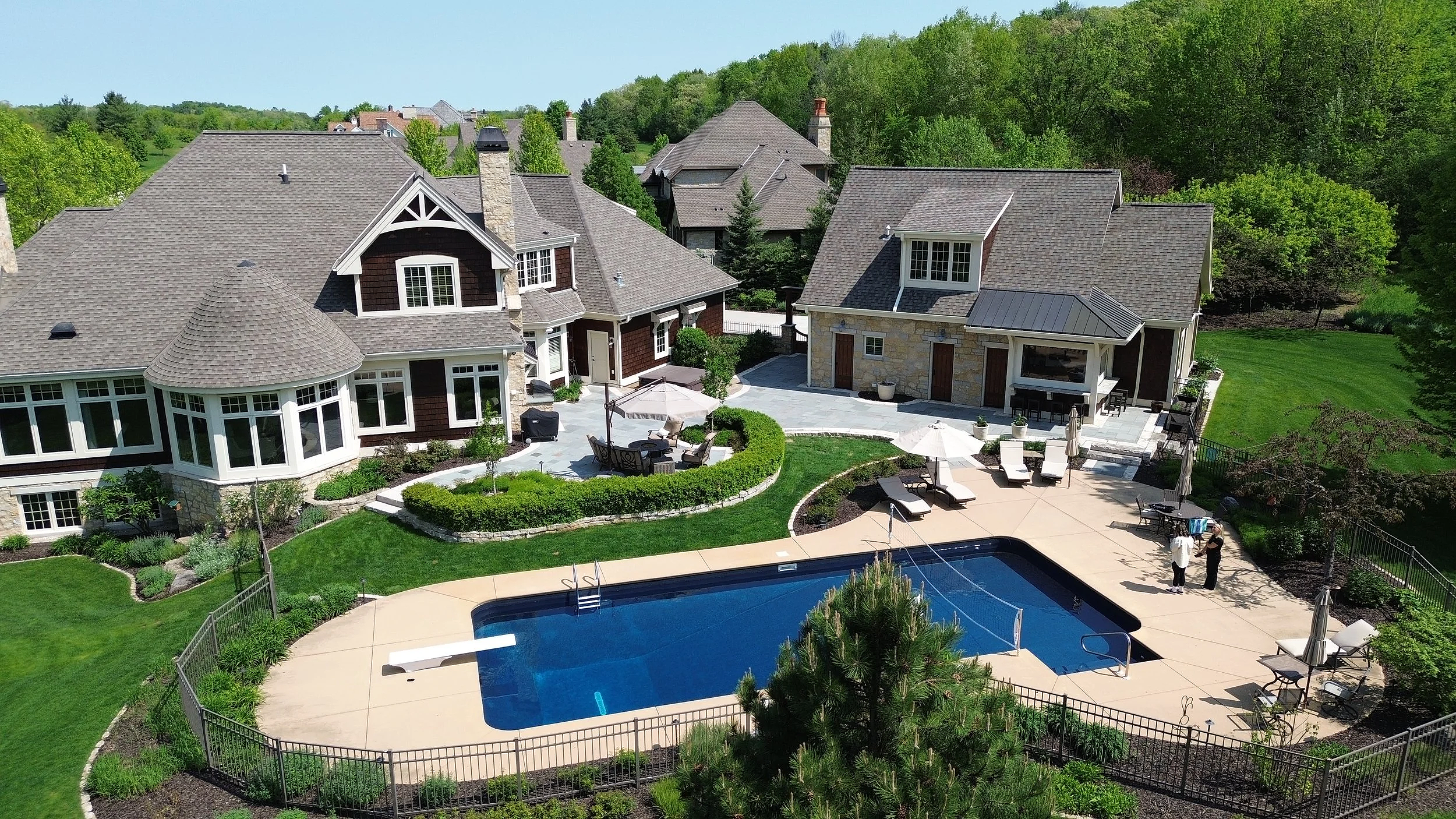 Backyard poolscape framed by a paver patio and planting beds in Menomonee Falls, WI