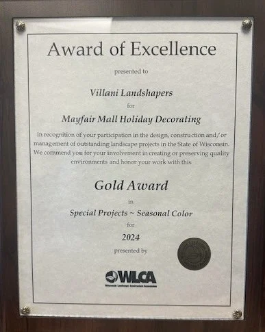 Award certificate for Villani Landshapers for Mayfair Mall Holiday Decorating, presented by WLCA, with a gold seal at the bottom right corner.
