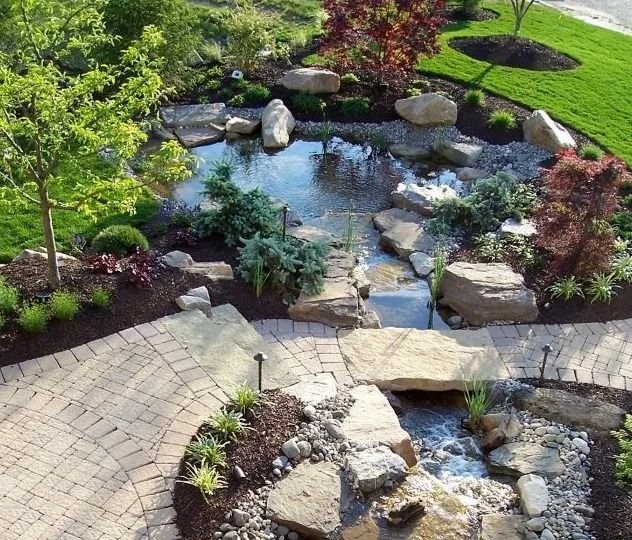 Curved paver patio with custom pond and waterfall in Palmer Township, PA by trusted patio contractors near me