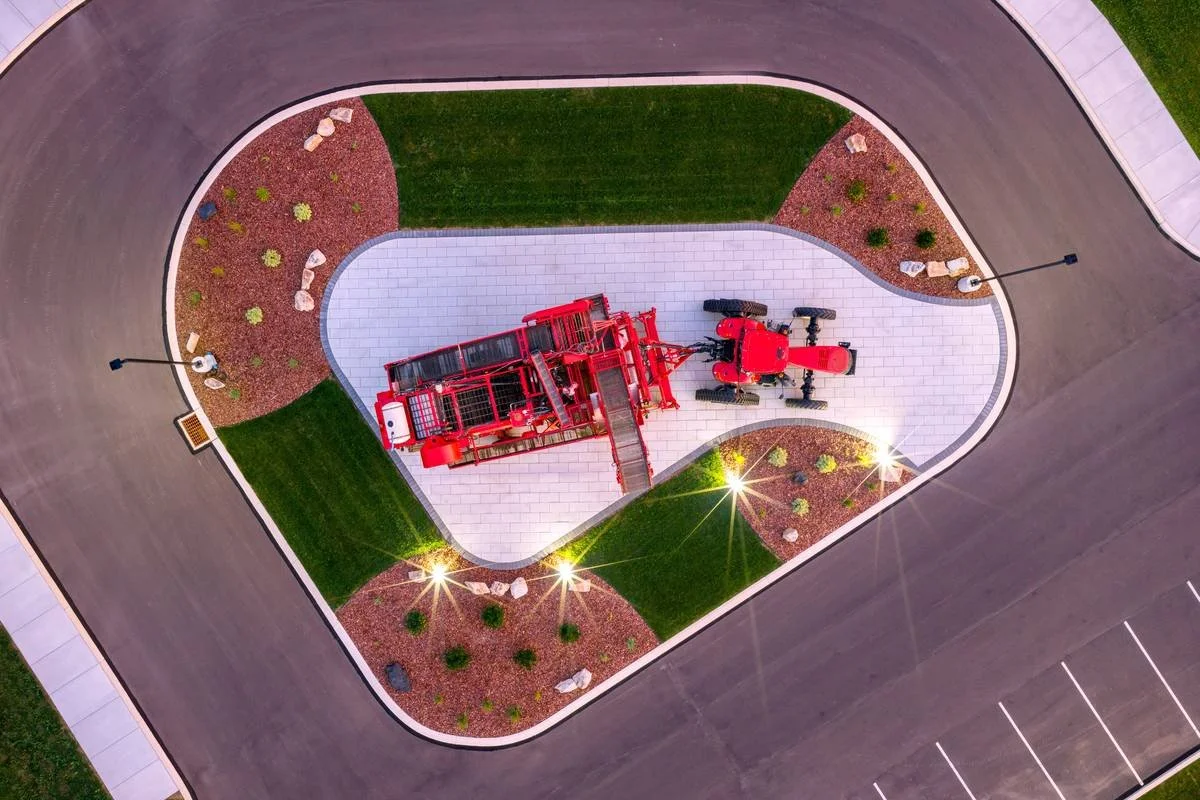 Overhead view of a curved paver equipment display surrounded by sod, mulch beds and plantings — GoldGlo Landscapes
