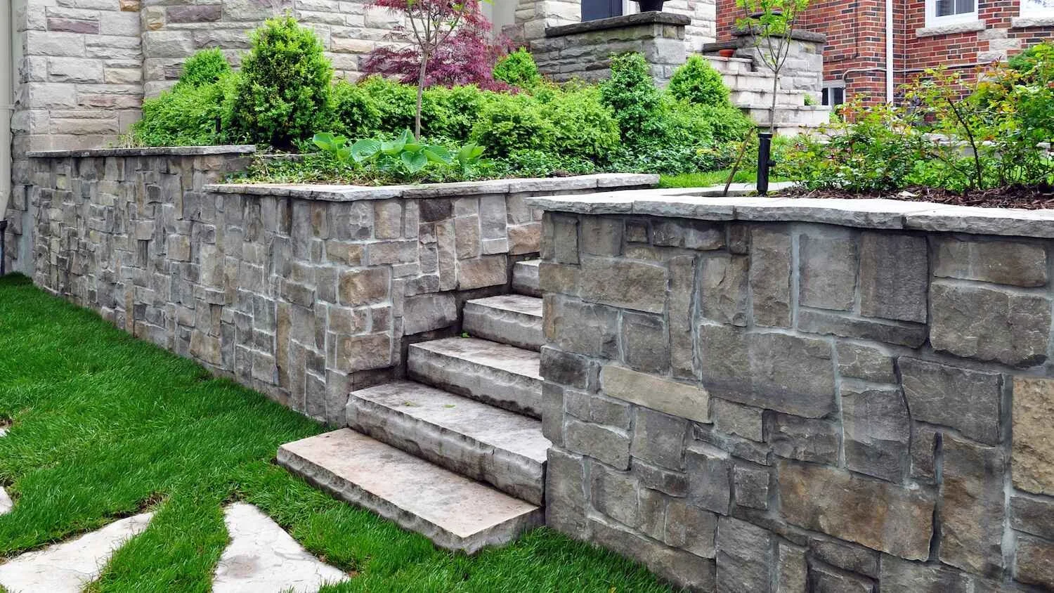 A stone retaining wall in a residential backyard in Westchester County, NY