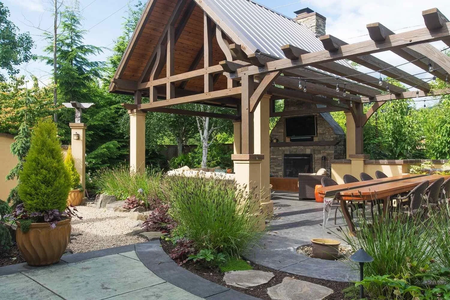 A rustic wooden backyard pavilion with a paver patio and plantings in Westchester County, NY