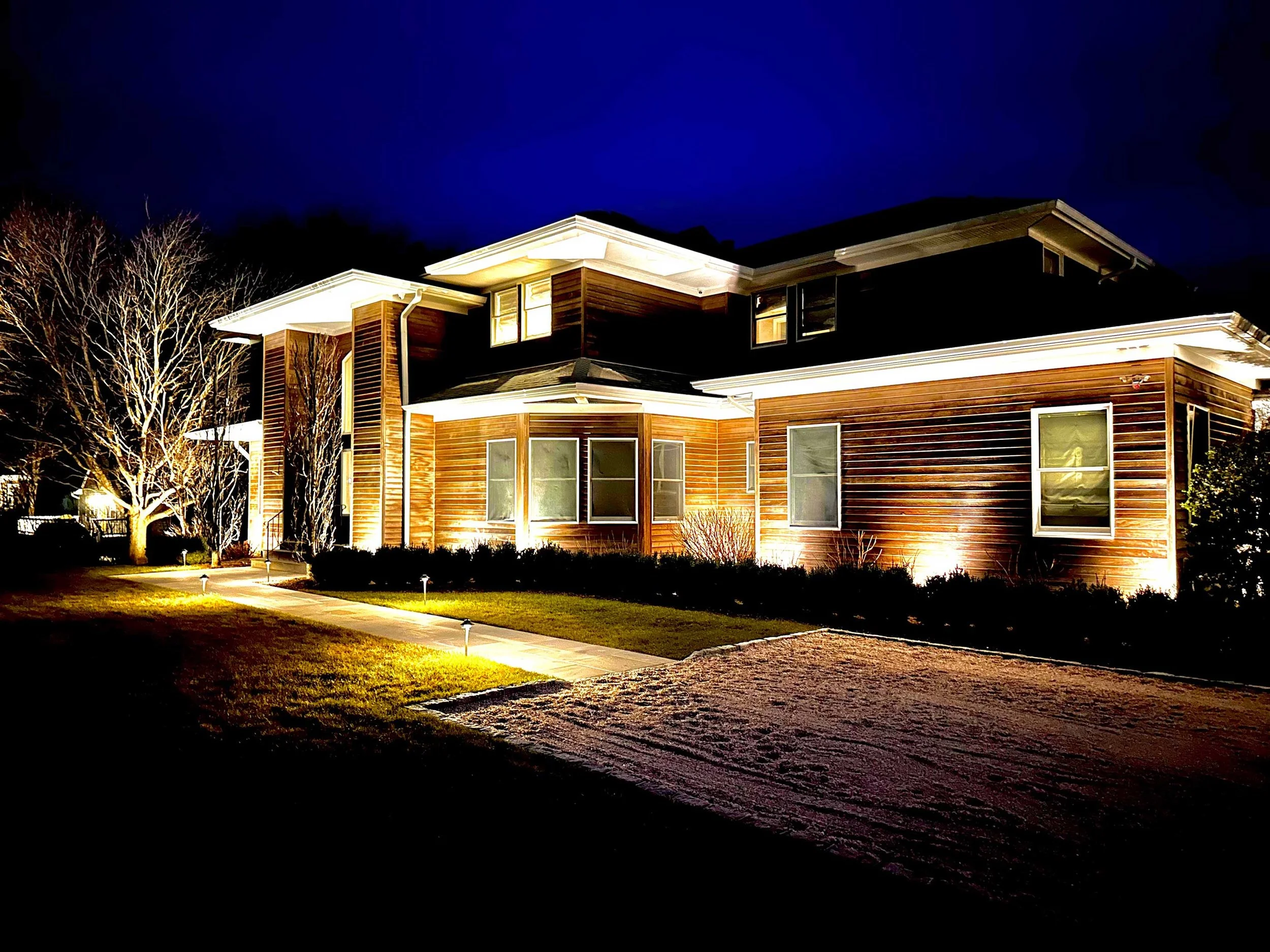 A residential home lit by outdoor lighting in Westchester County, NY