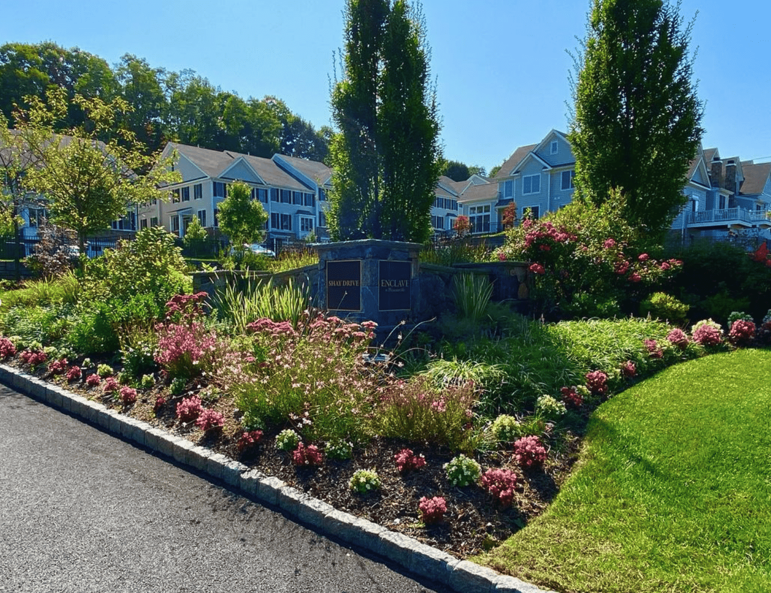 The entrance to an apartment complex with vibrant flowers and beautiful landscaping in  Westchester County, NY