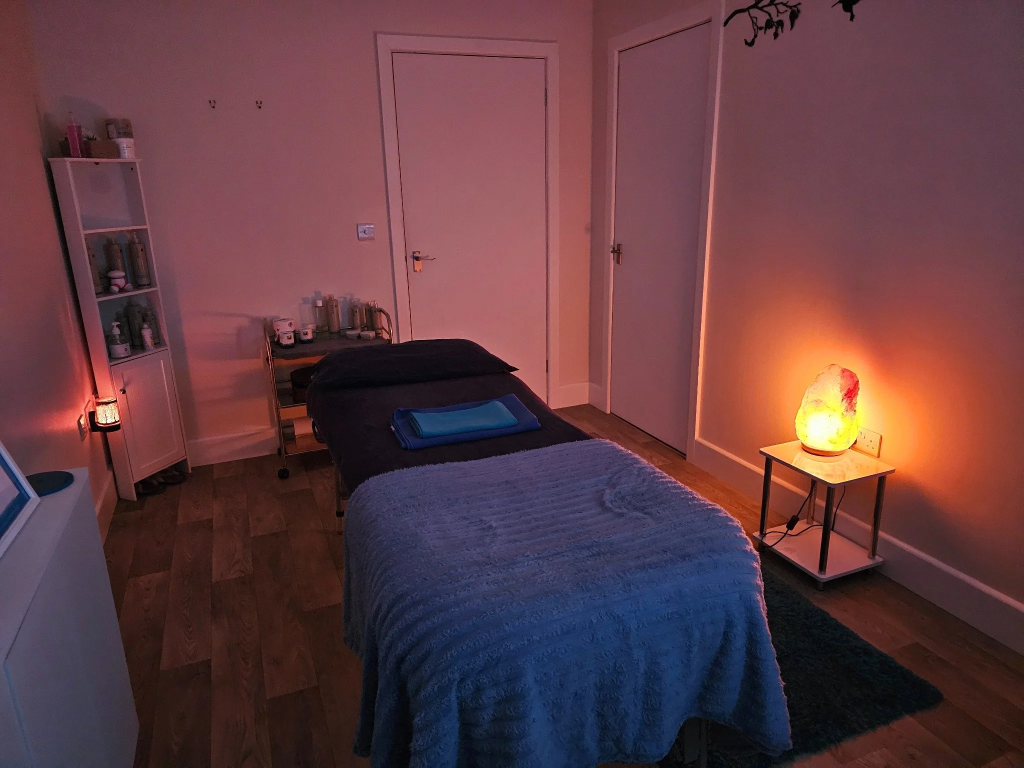 Massage table prepared in the softly lit E & T Massage Therapies treatment room.