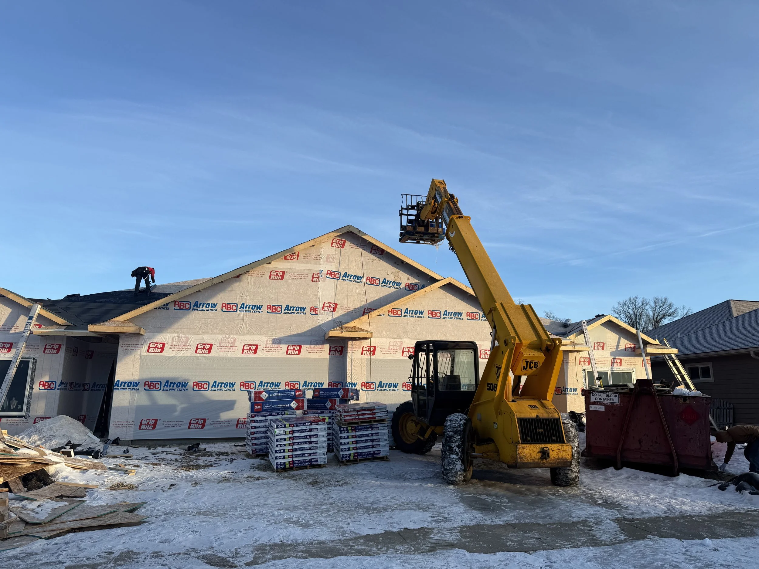 A new construction in progress of being built. It is getting the roof shingles installed in this picture.