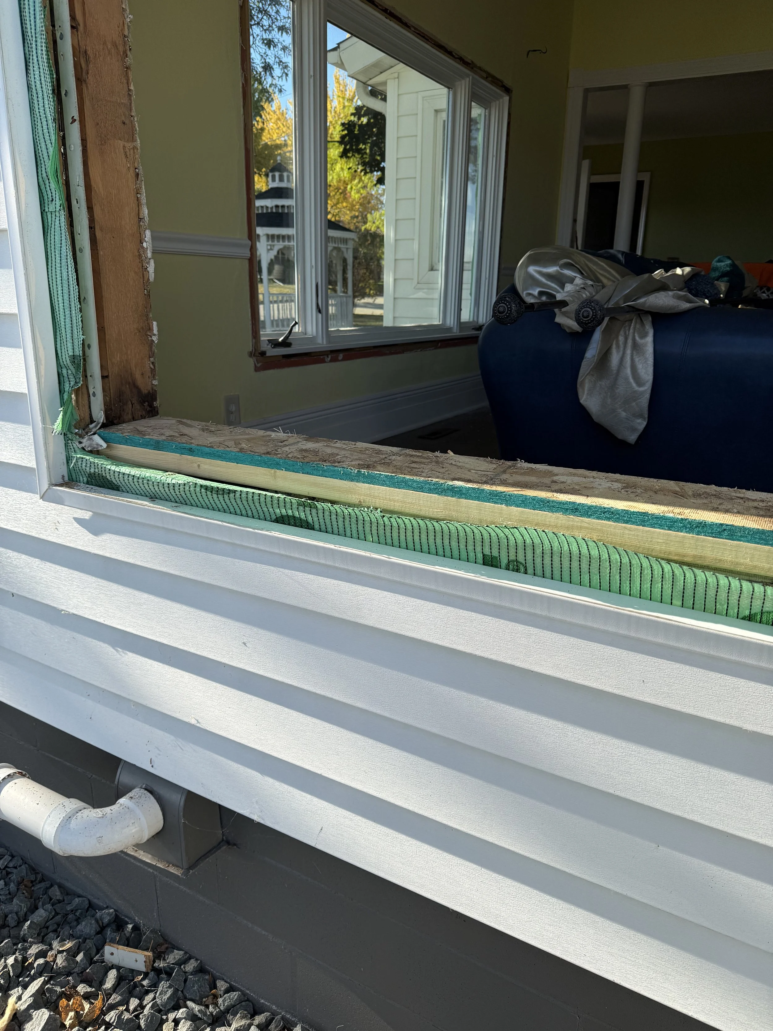 A window open with the sill replaced with new framing and ready for flashing before the window is installed.