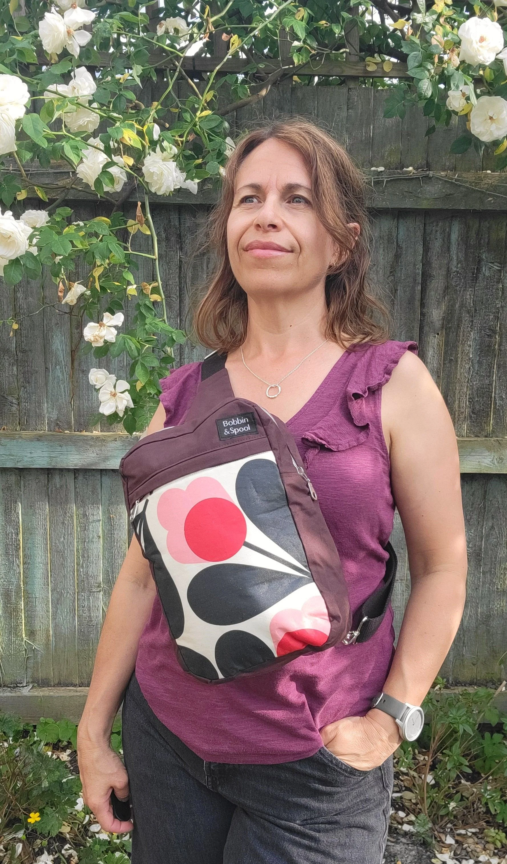 Oxblood retro flower sling bag on chest.jpg