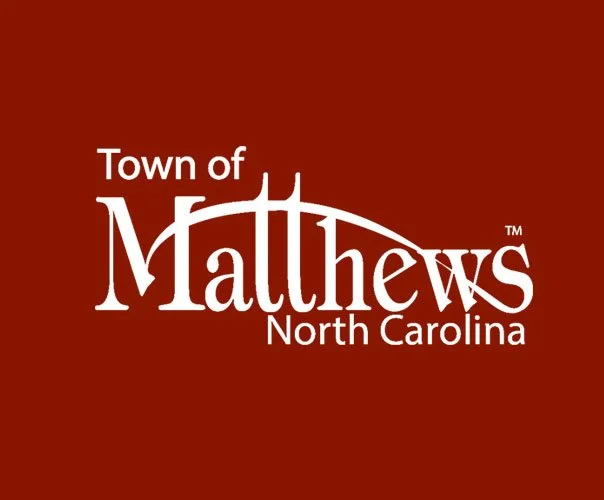 Logo for the Town of Matthews, North Carolina with white text on a maroon background.