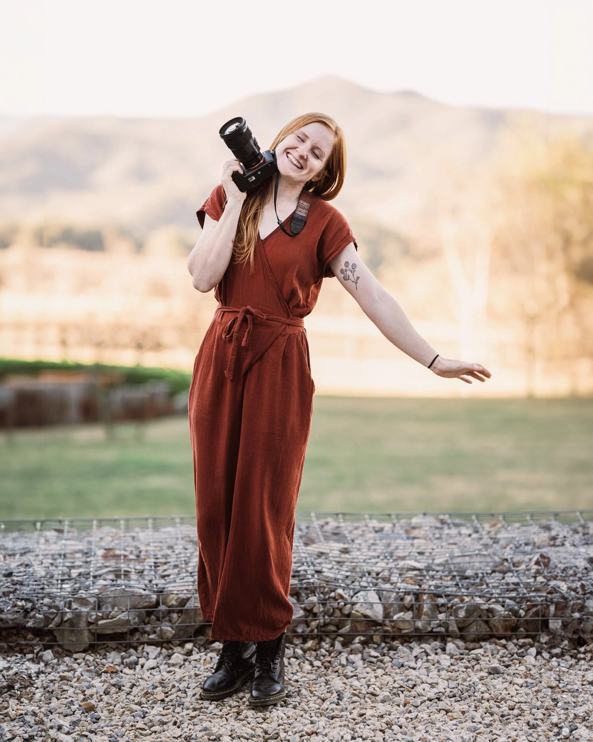 caitlin king - blue mountains based wedding and business photographer, standing at a wedding venue with her camera in hand