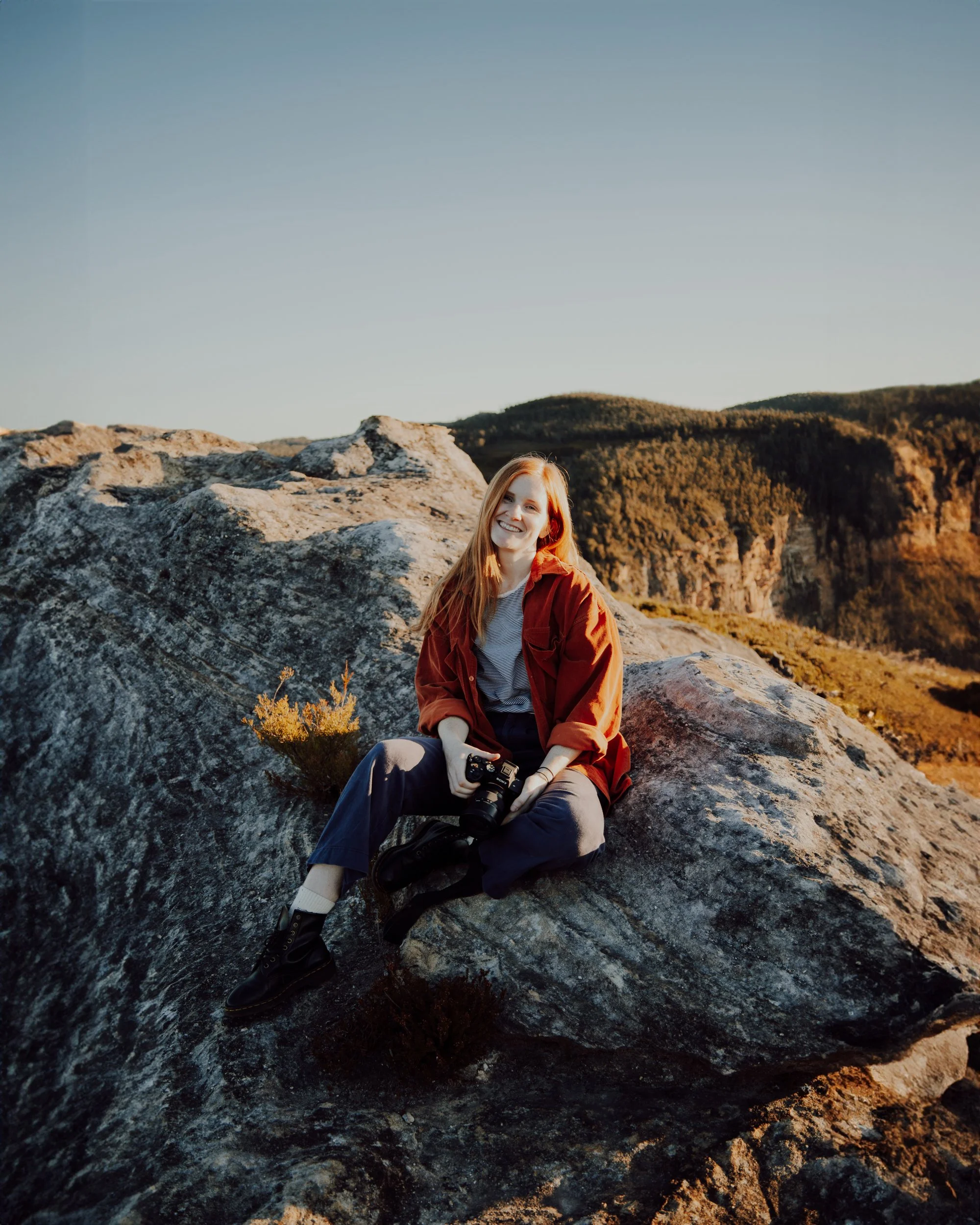 caitlin king - blue mountains based wedding and business photographer, sitting atop a cliff in the blue mountains national park