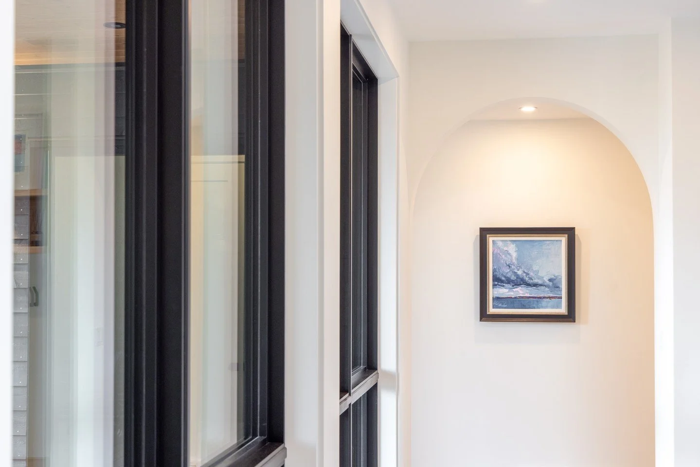 The way one space moves into another matters. Clean lines, framed openings, and subtle curves all play a role in guiding that transition - without needing to call attention to themselves.

Here, a soft arch offsets the sharper geometry of the windows