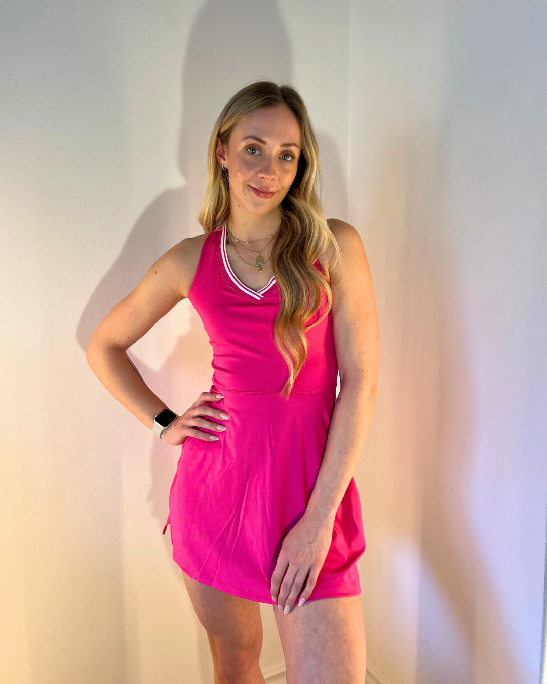Eliza wears the tiebreaker tennis dress from Wilson in fuschia