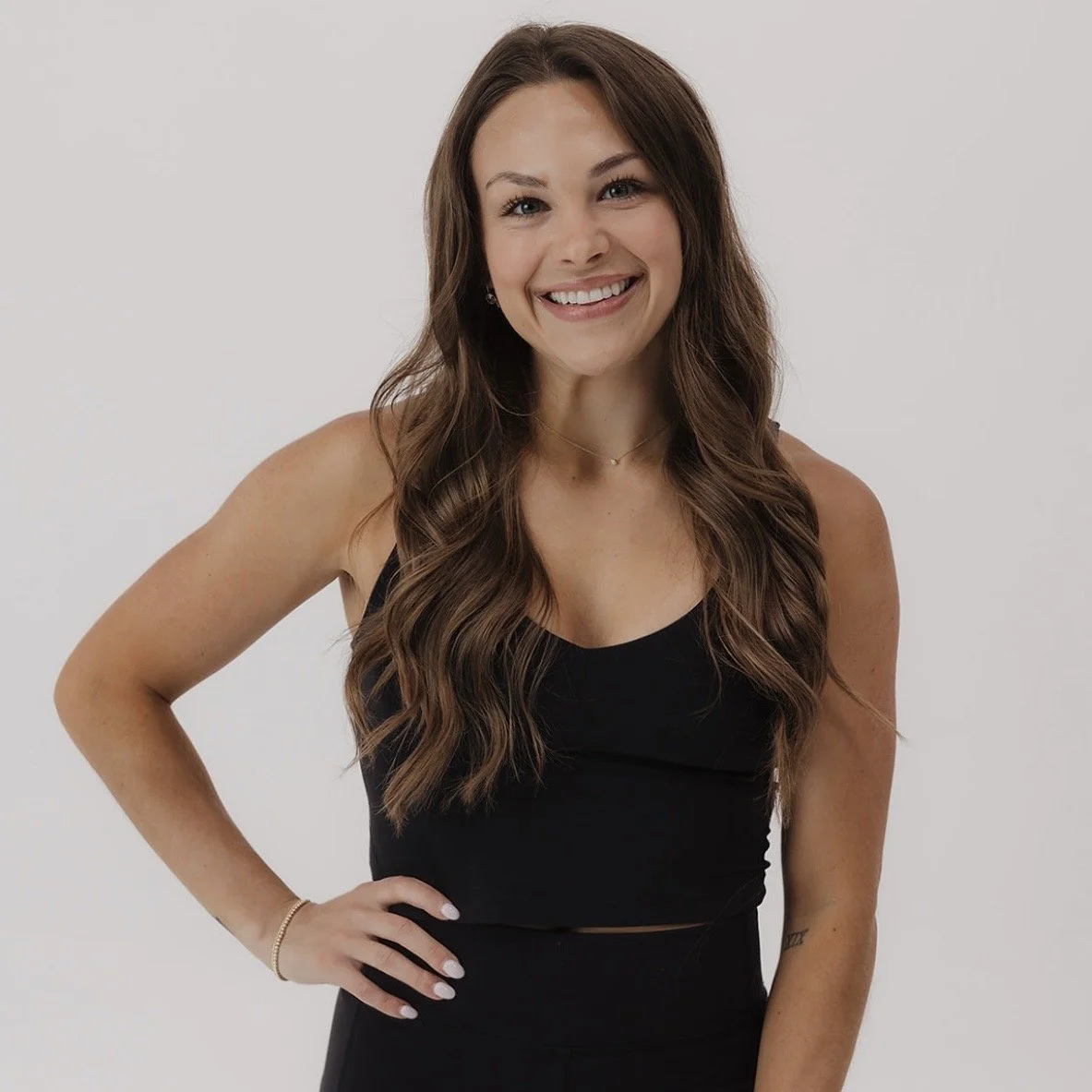 woman smiling with one hand on hip