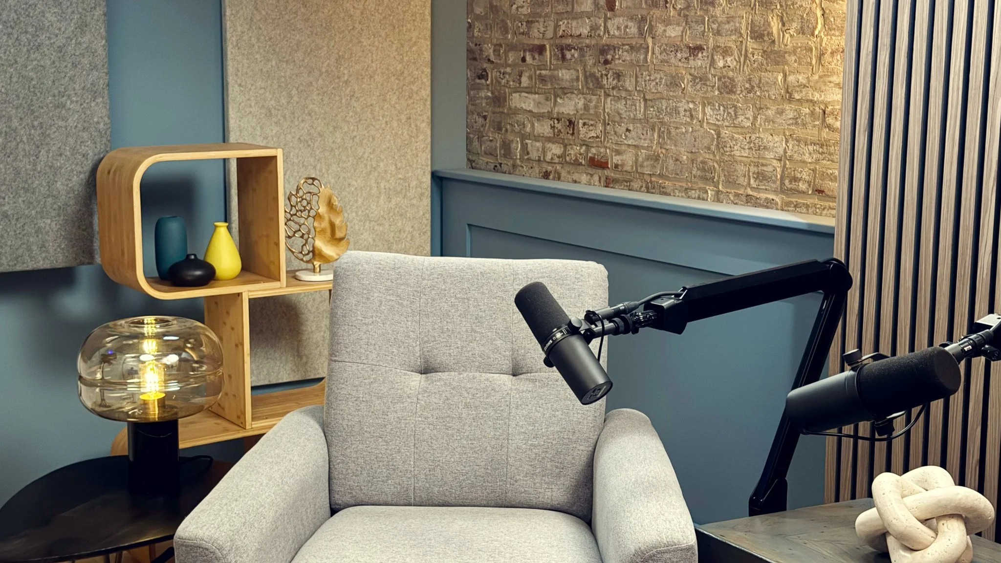 Podcast studio left-hand seat with Shure microphone and Canon camera setup at NMP Films studio