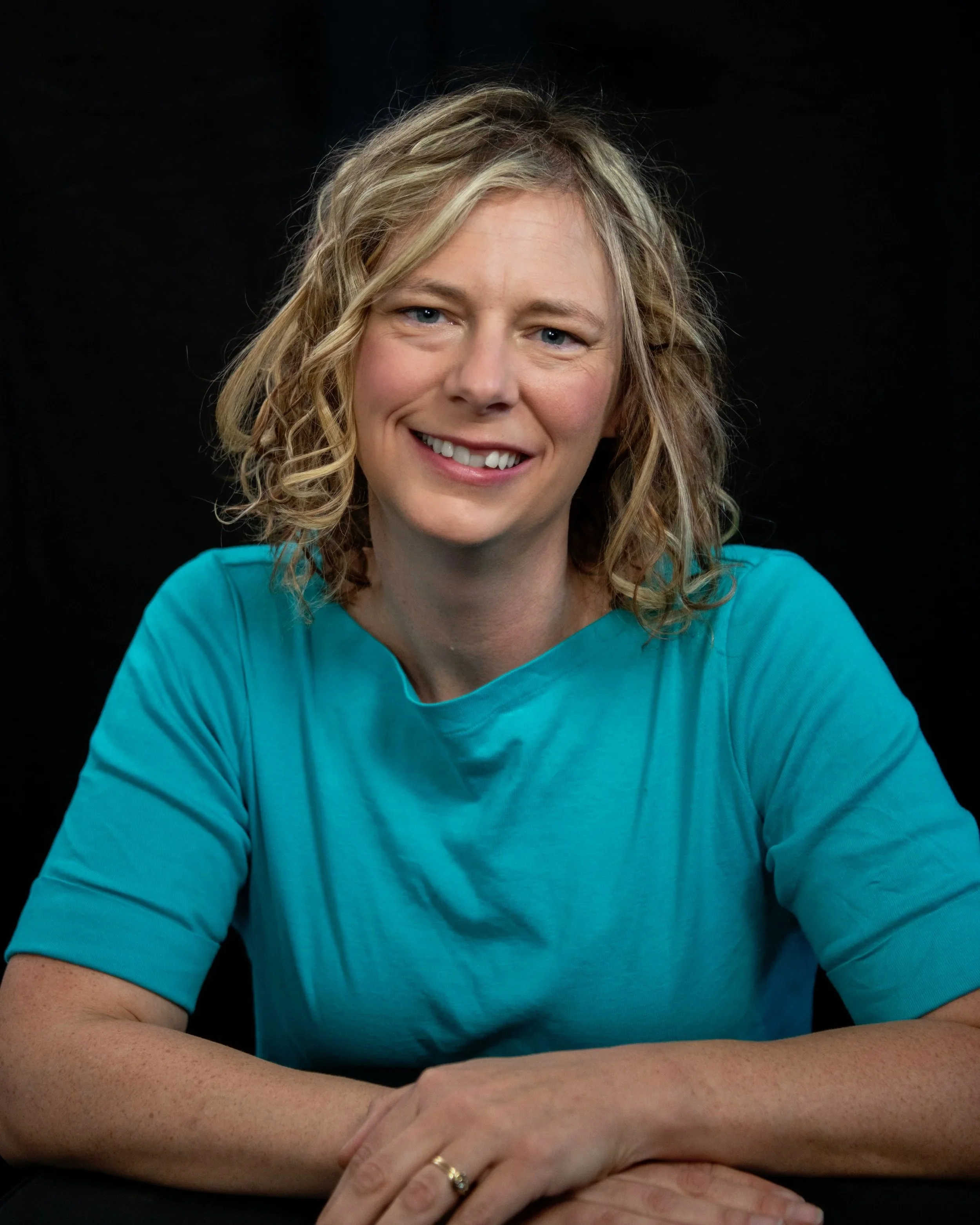 Professional headshot of Samantha Roberts smiling in a blue shirt with her arms crossed in front of her. She is the counselor described in the text.