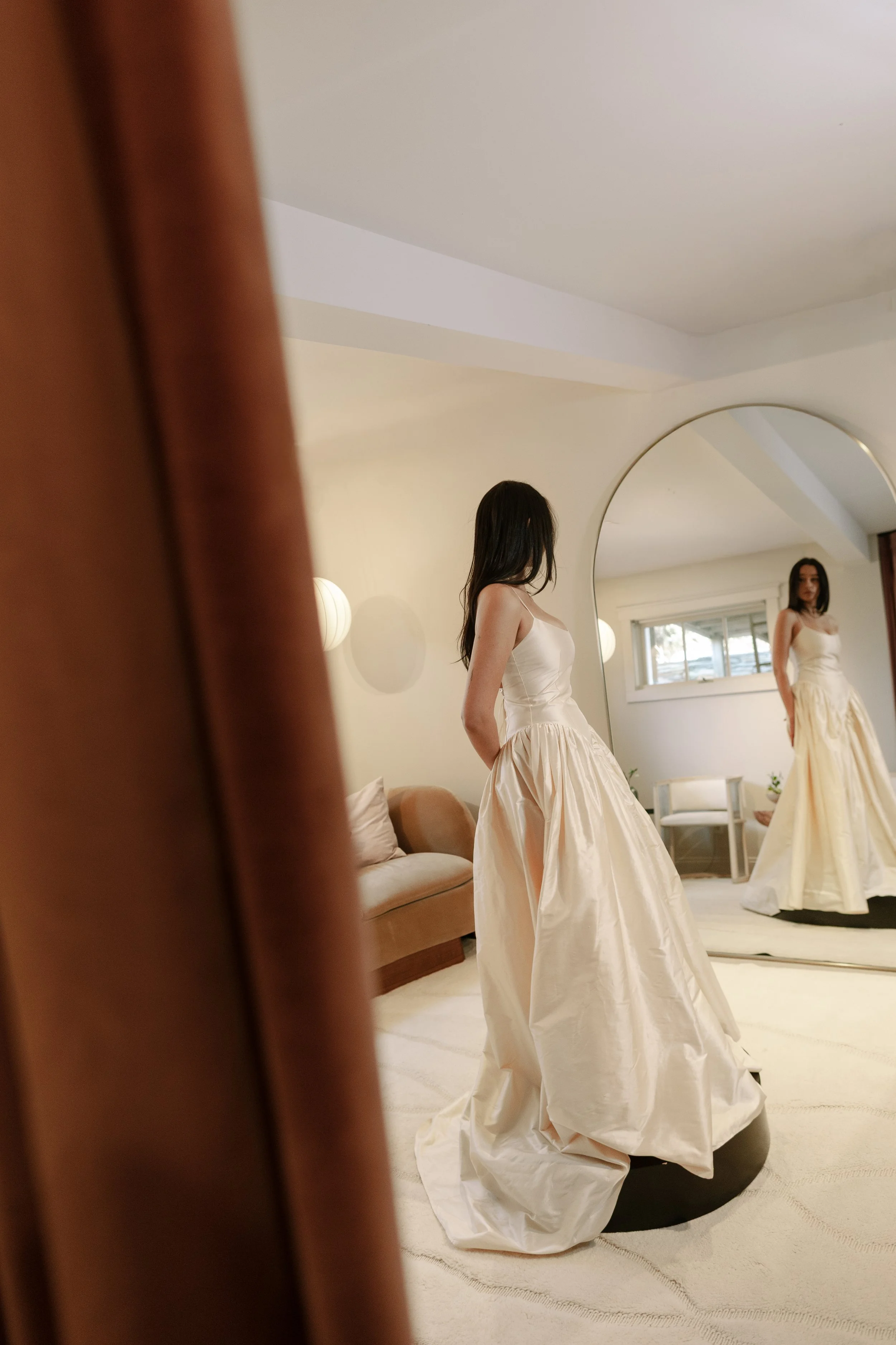 Woman standing in front of mirror in white bridal dress