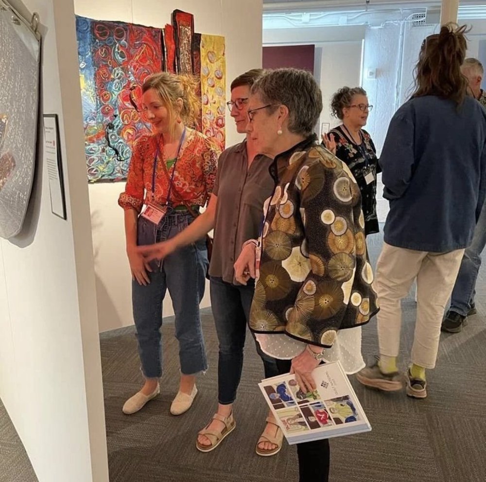 Émilie Trahan, Kelly Spell, and Pilar Donoso talk about Kelly's quilt at Quilt National 2023. Photo by Loreto Silva.