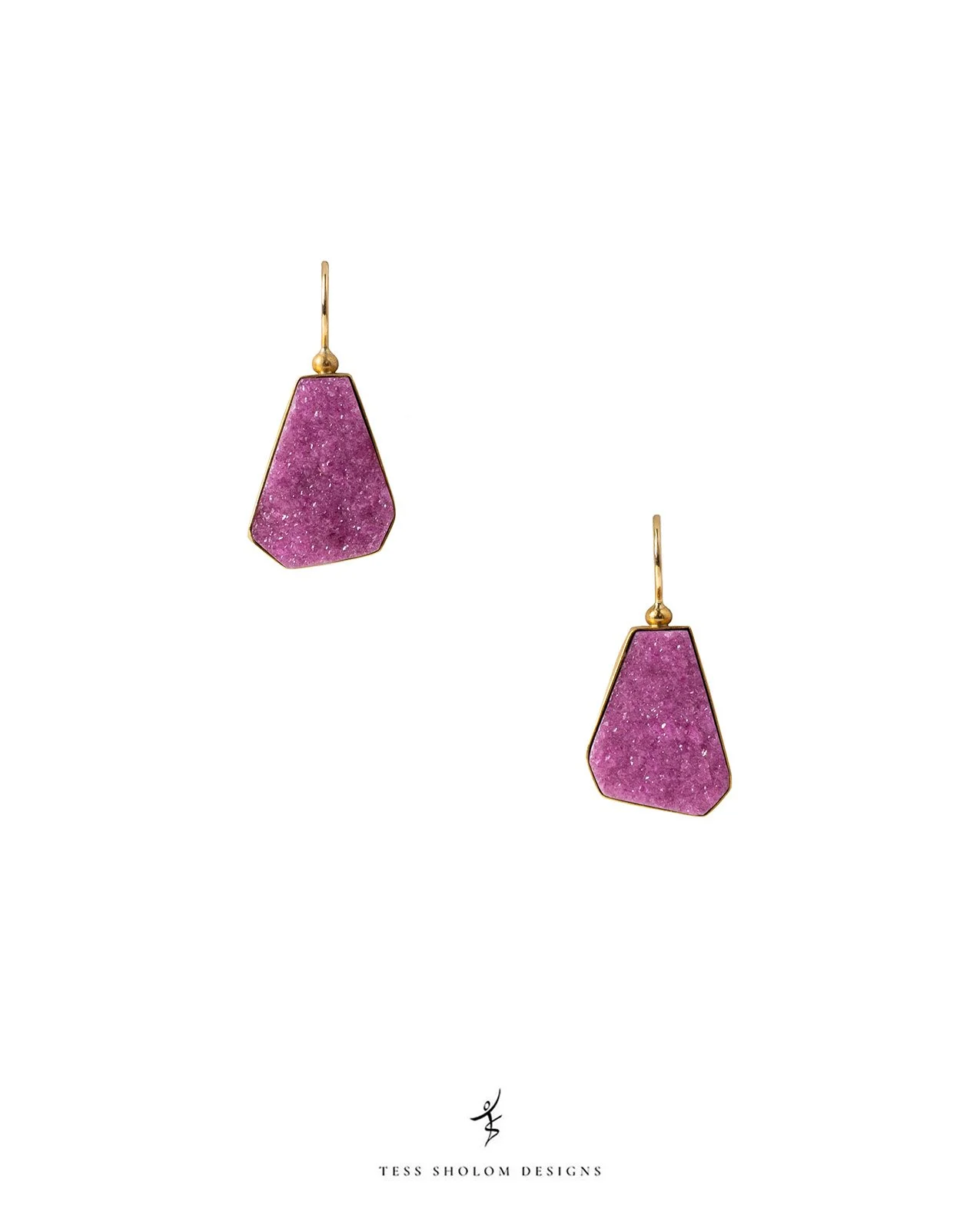 Pair of earrings with purple, trapezoid-shaped stones set in gold frames against a white background, with Tess Sholom Designs logo below.