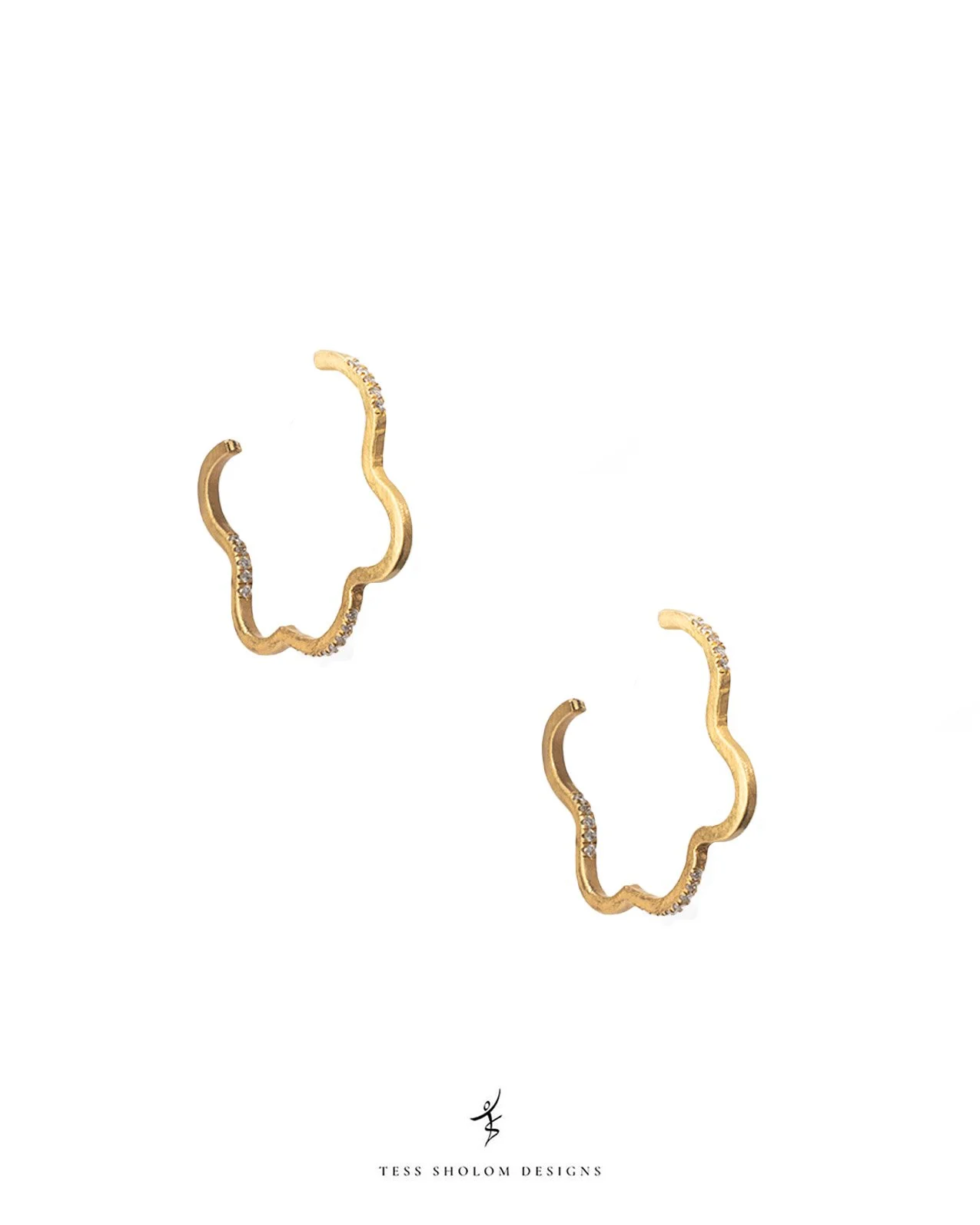 A pair of gold earrings with a wavy design and small embedded diamonds on a white background with text 'TESS SHOLOM DESIGNS' at the bottom.