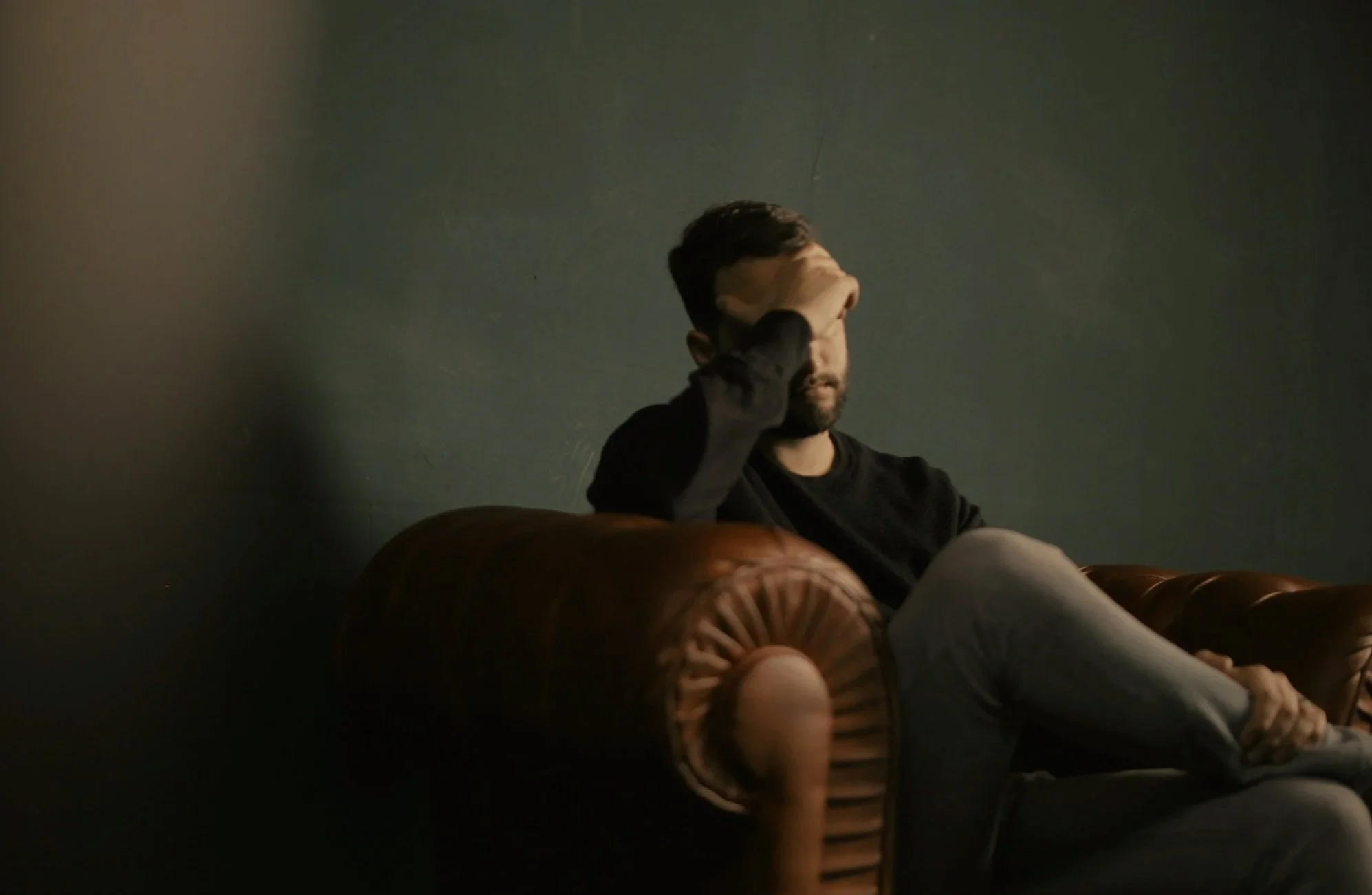 a man on a couch, looking stressed
