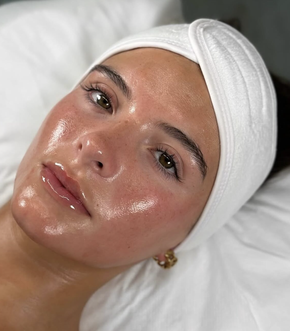 A woman wearing a white towel on her head, gazing off into the distance with a serene expression.