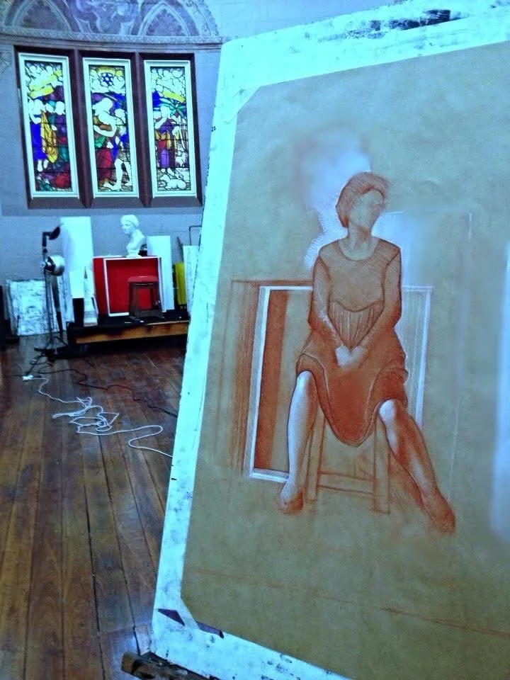 An artist's unfinished portrait of a woman sitting on a chair with legs apart and hands clasped in her lap. The sketch is on a large canvas and appears to be in progress, with some parts more detailed than others.