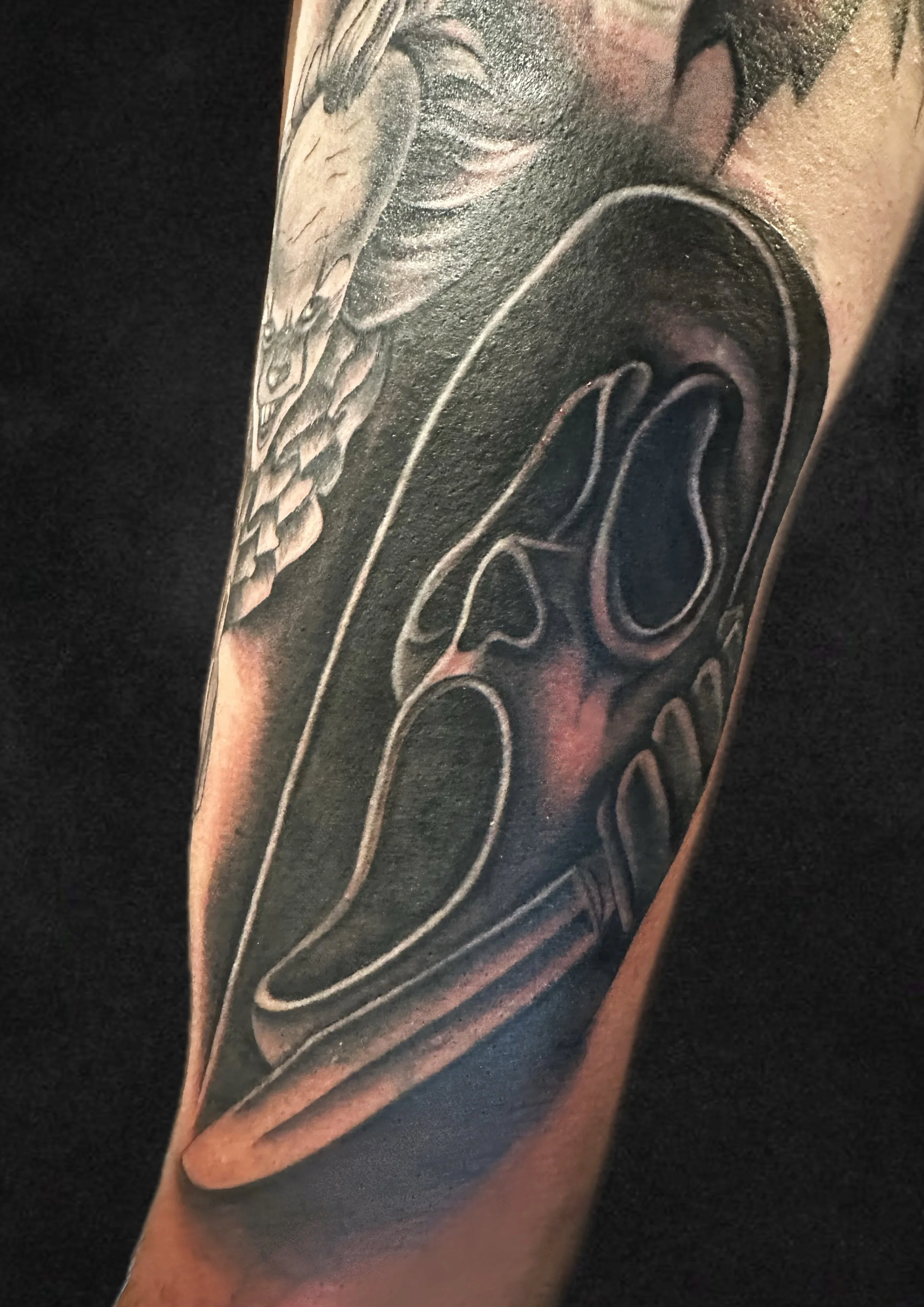 A tattoo of a soda can with a pull-tab and a straw, rendered in black and gray ink.