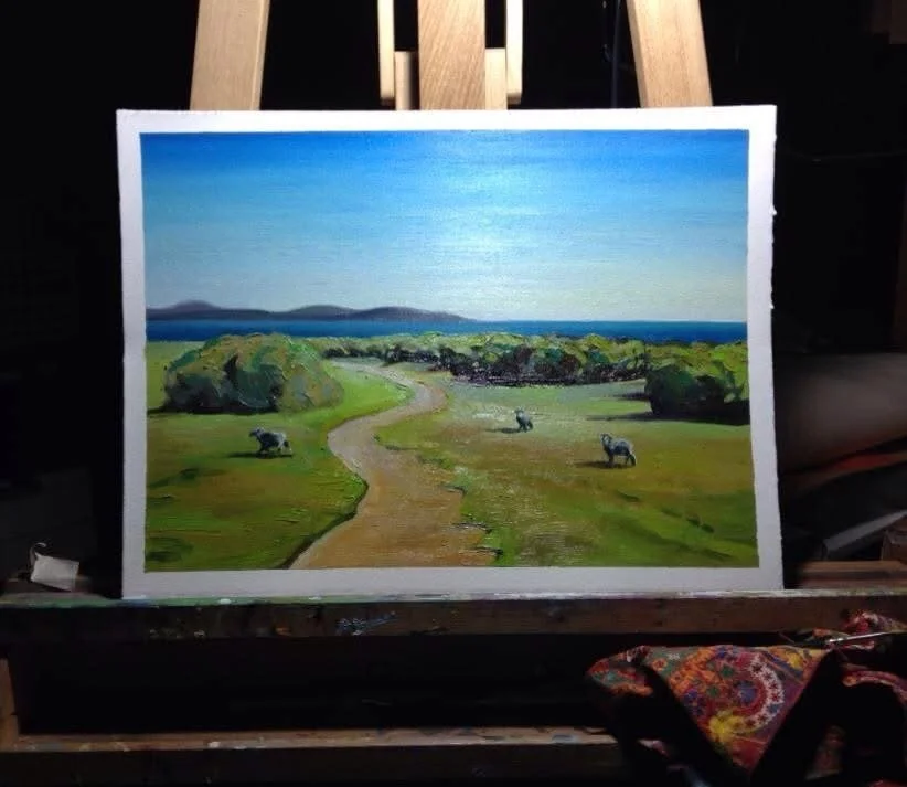 A landscape painting of a winding dirt path through green fields, with trees and shrubs, leading to a distant coastline with mountains and a bright blue sky.