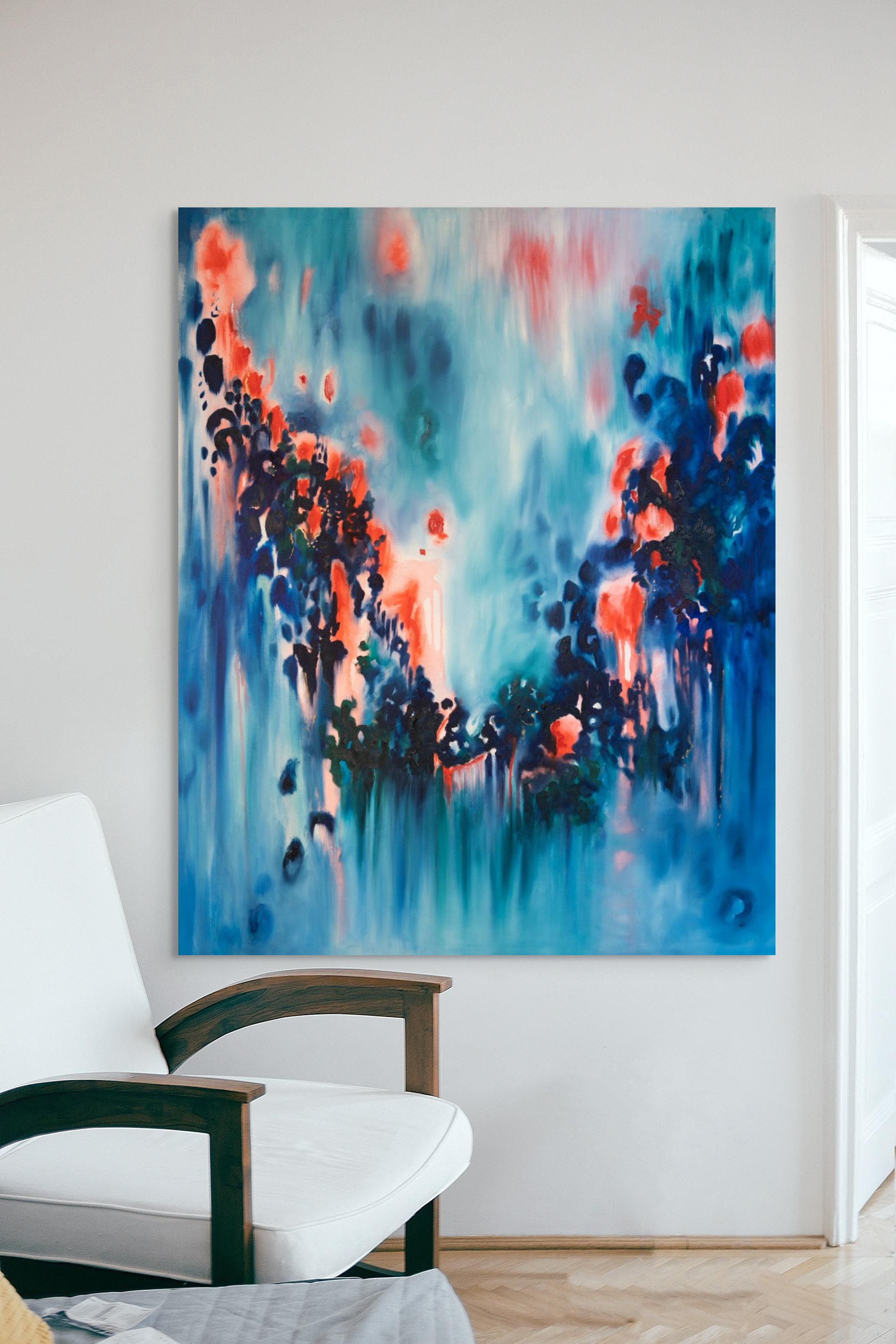 An abstract ocean painting with flowing blue, red, and green colors hanging on a white wall, next to a white chair with dark wooden armrests in a bright room.