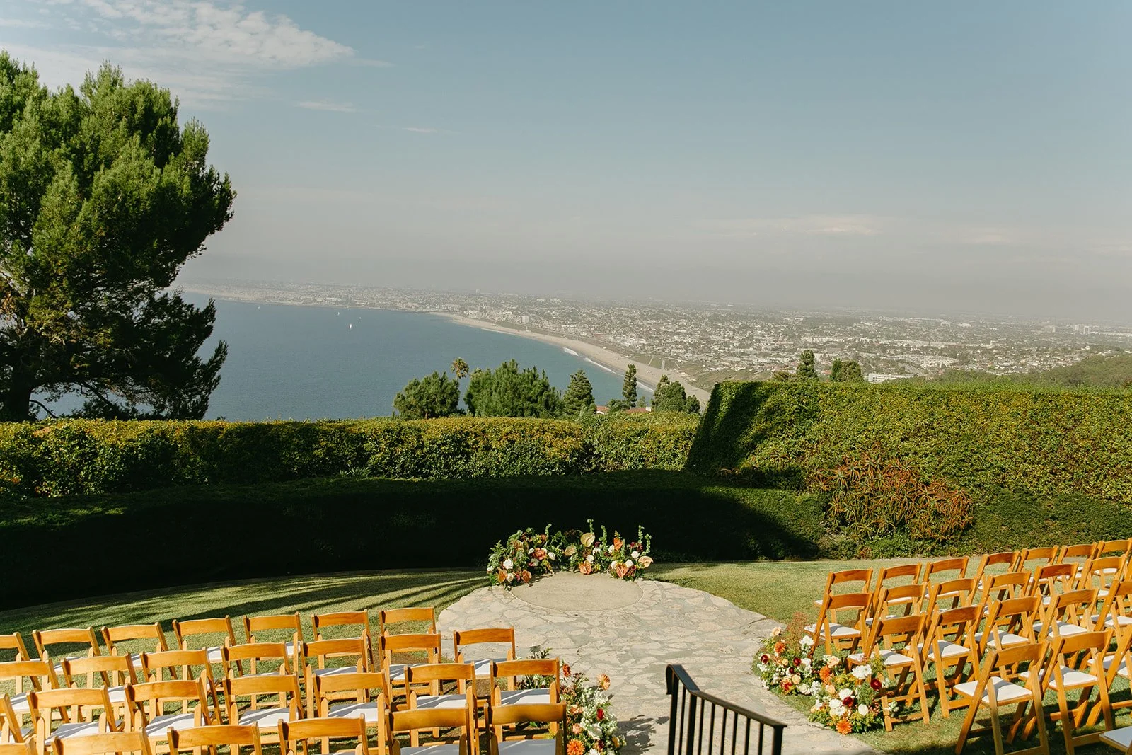 Wide view of the outdoor ceremony setup overlooking the coastline during a La Venta Inn wedding.