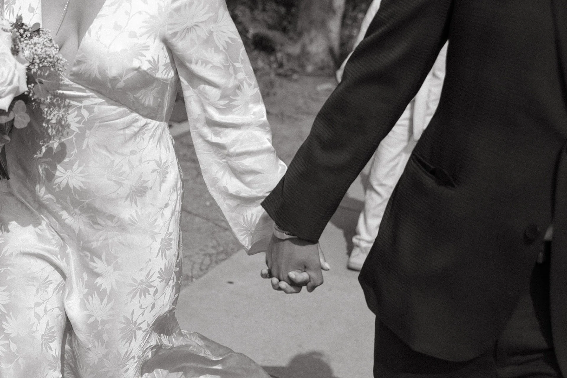 Closeup of a couple holding hands walking the the street